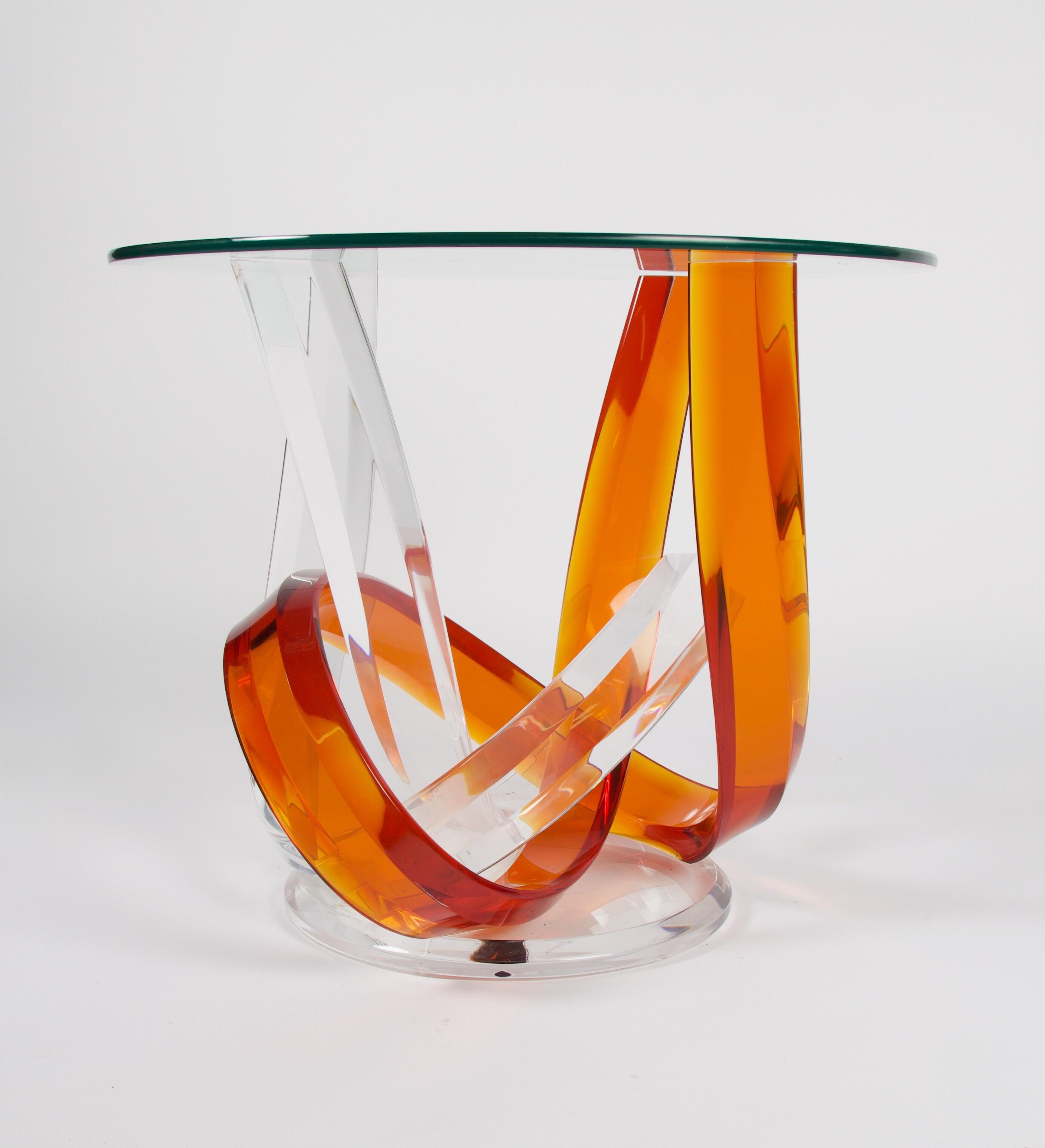 A signed Haziza Lucite side table with intertwined clear and orange lucite pieces with a round beveled glass top. A great accent piece to add a vibrant pop of color to your decor. Great as a bedside table or beside a chair.
By the time Shlomi