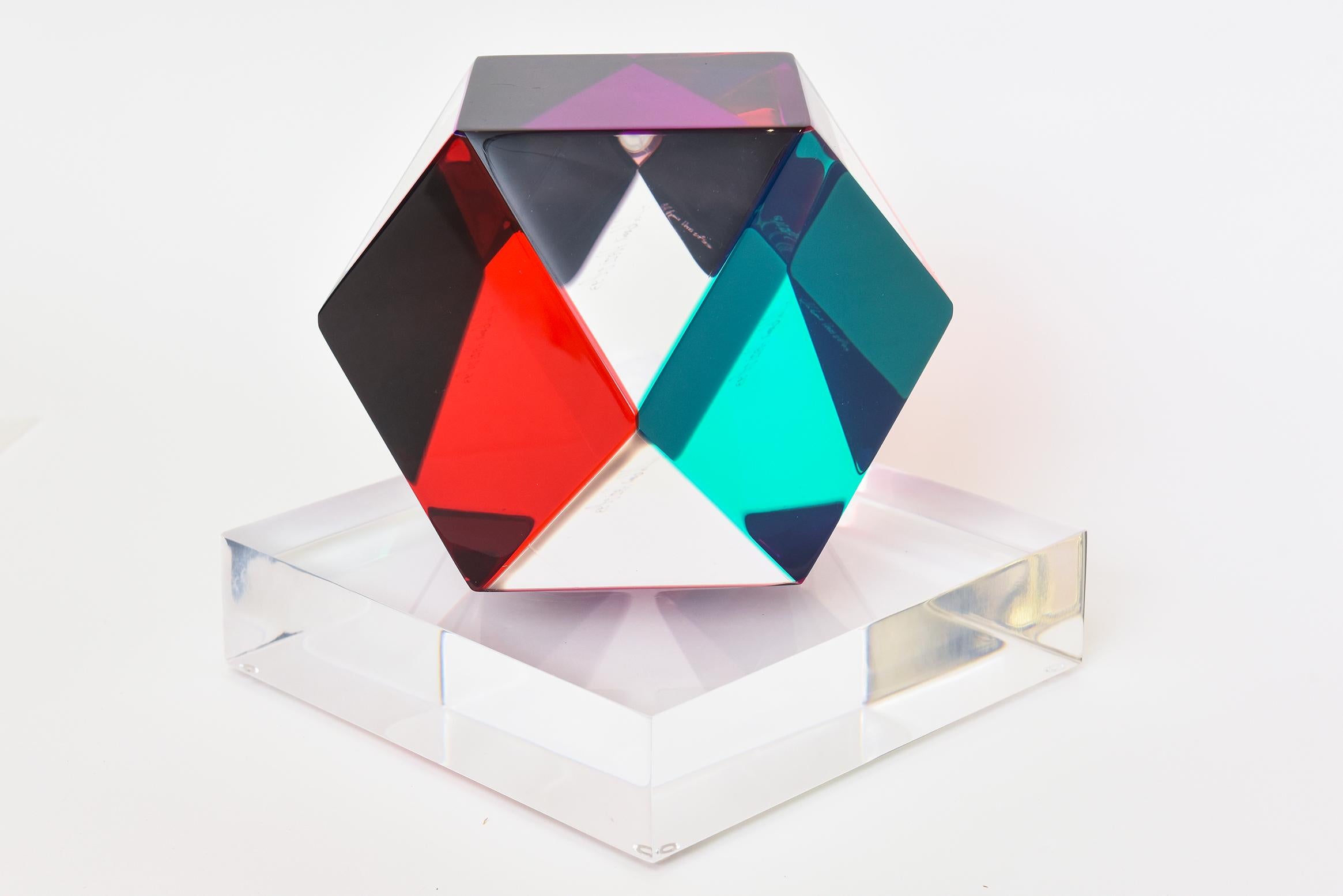 This amazing signed Haziza lucite 13 sided polygon lucite sculpture changes color when light hits it differently. It is called the Tridecagon. The initial colors you see are clear, emerald green, purple and red. Other colors come into play when it