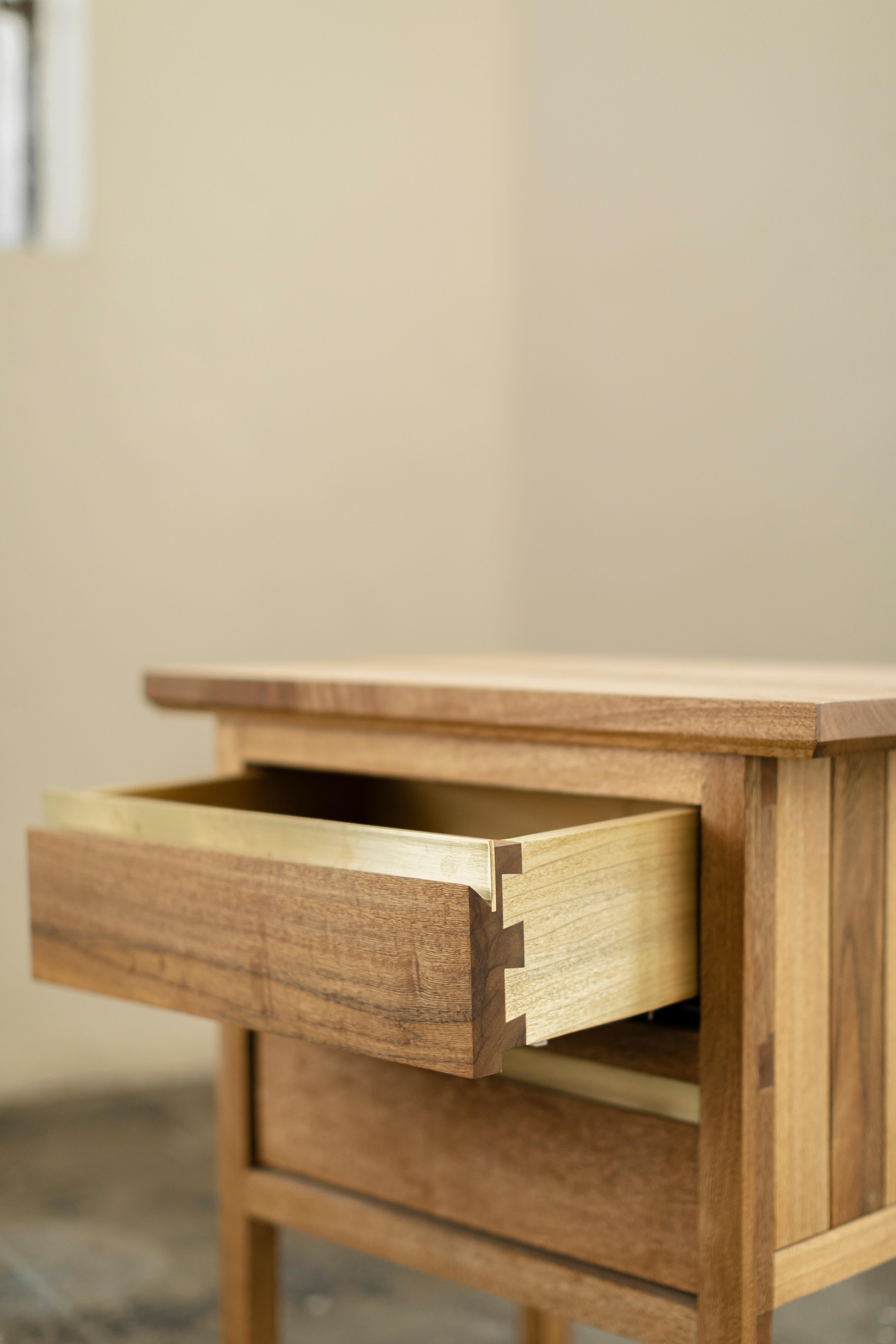 HB collection wooden nightstand made of oak or tzalam wood. Brass details in the drawer.