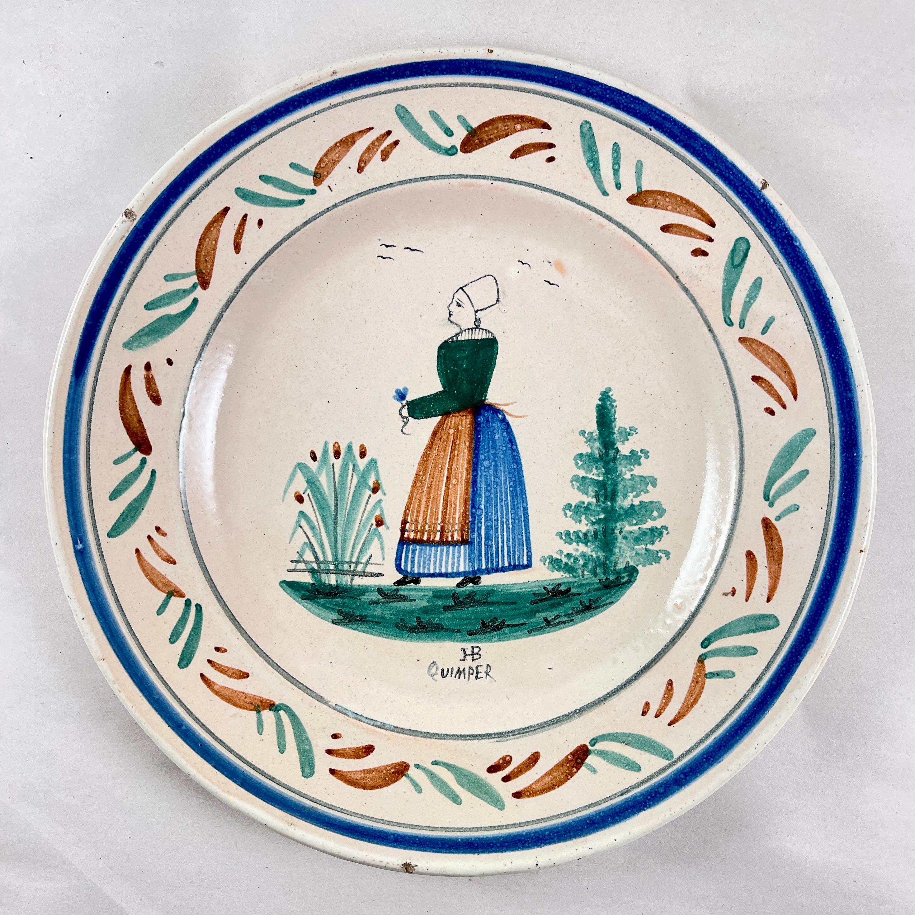 From the Grand Maison Quimper factory, a dinner plate, France, circa 1910.

This piece shows the mark registered in 1882. The HB represents the de la Hubaudière family name and the factory founders name, Bousquet. In 1904, the word Quimper was added