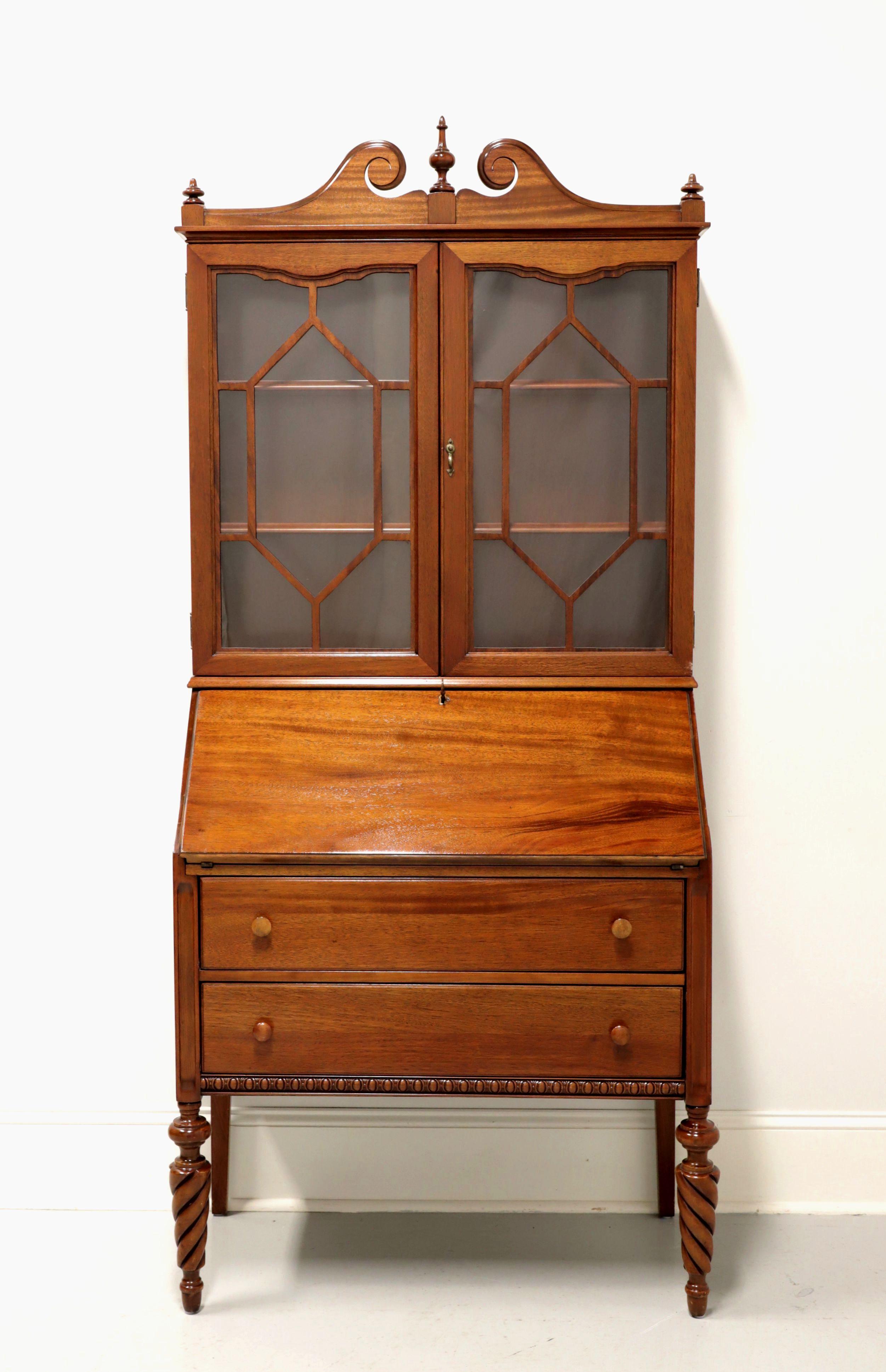 A Georgian style secretary desk by H.E. Shaw Furniture. Mahogany with brass hardware, wood drawer knobs, scroll pediment top with three finials, an elevated case, decorative cockbeading at apron and tapered twist front legs. Upper bookcase has two