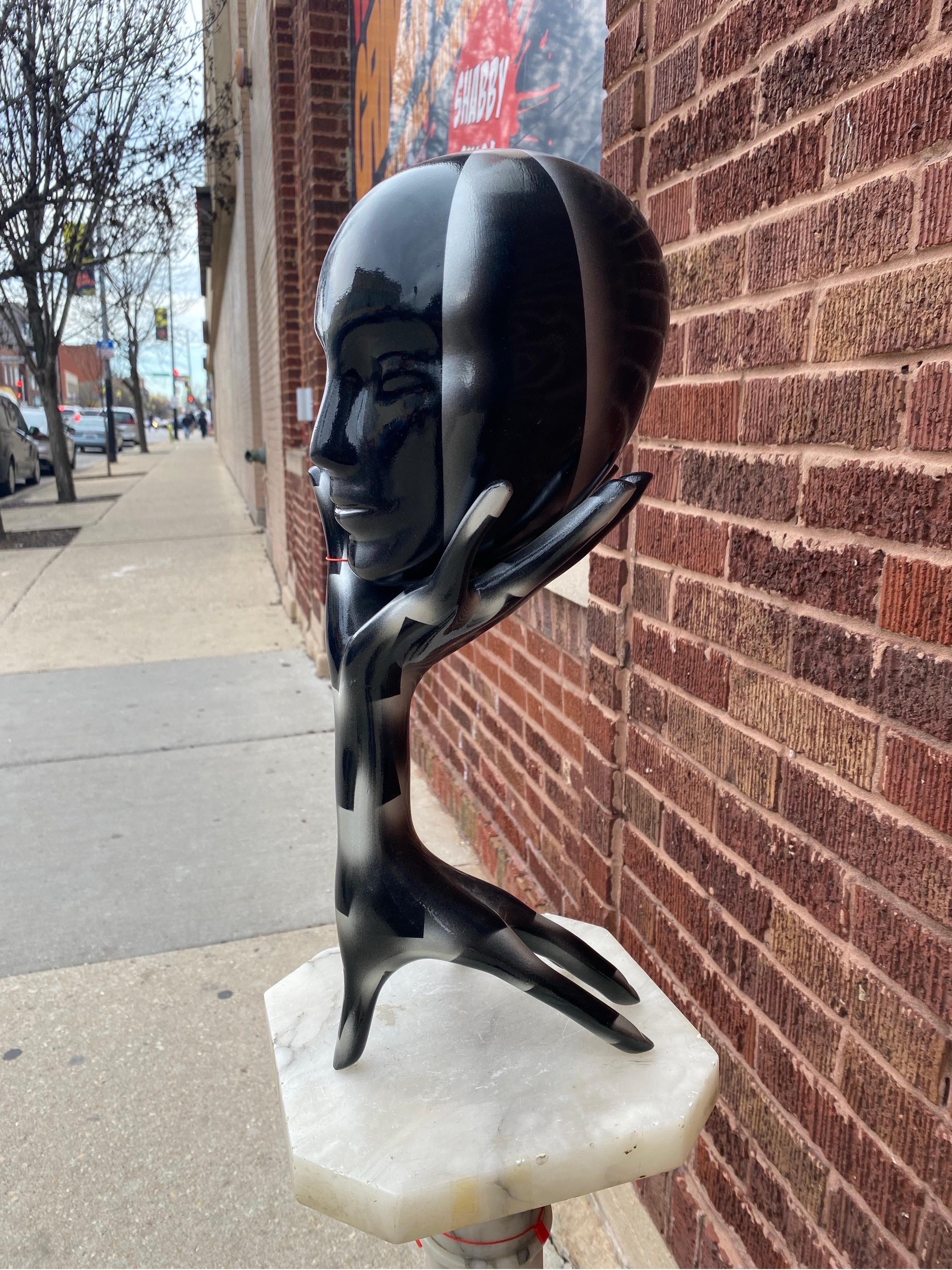 Tête-en-main 1990 Sculpture courte en noir et argent

Cette élégante sculpture en bois peint en noir et argent représente un bras avec une main tendue à chaque extrémité. Une tête est en équilibre sur le bout des doigts de la main. La tête est