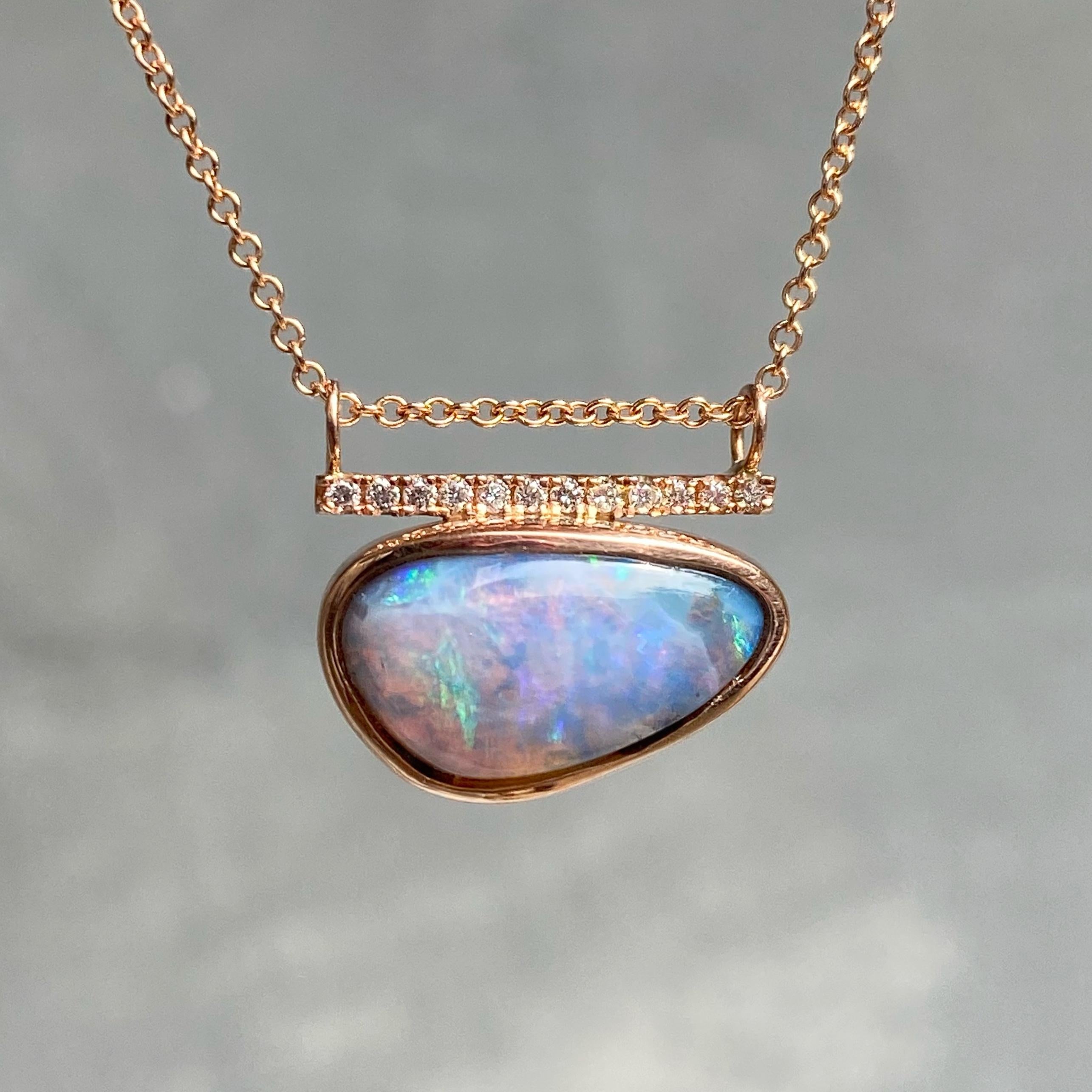 A mystical smoky Boulder Opal slides with grace in the Head in the Clouds Rose Gold Opal Necklace No. 15.  The high dome of the purple opal plays with light as it passes through the stone, casting quick glances of pink and blue and waves of emerald