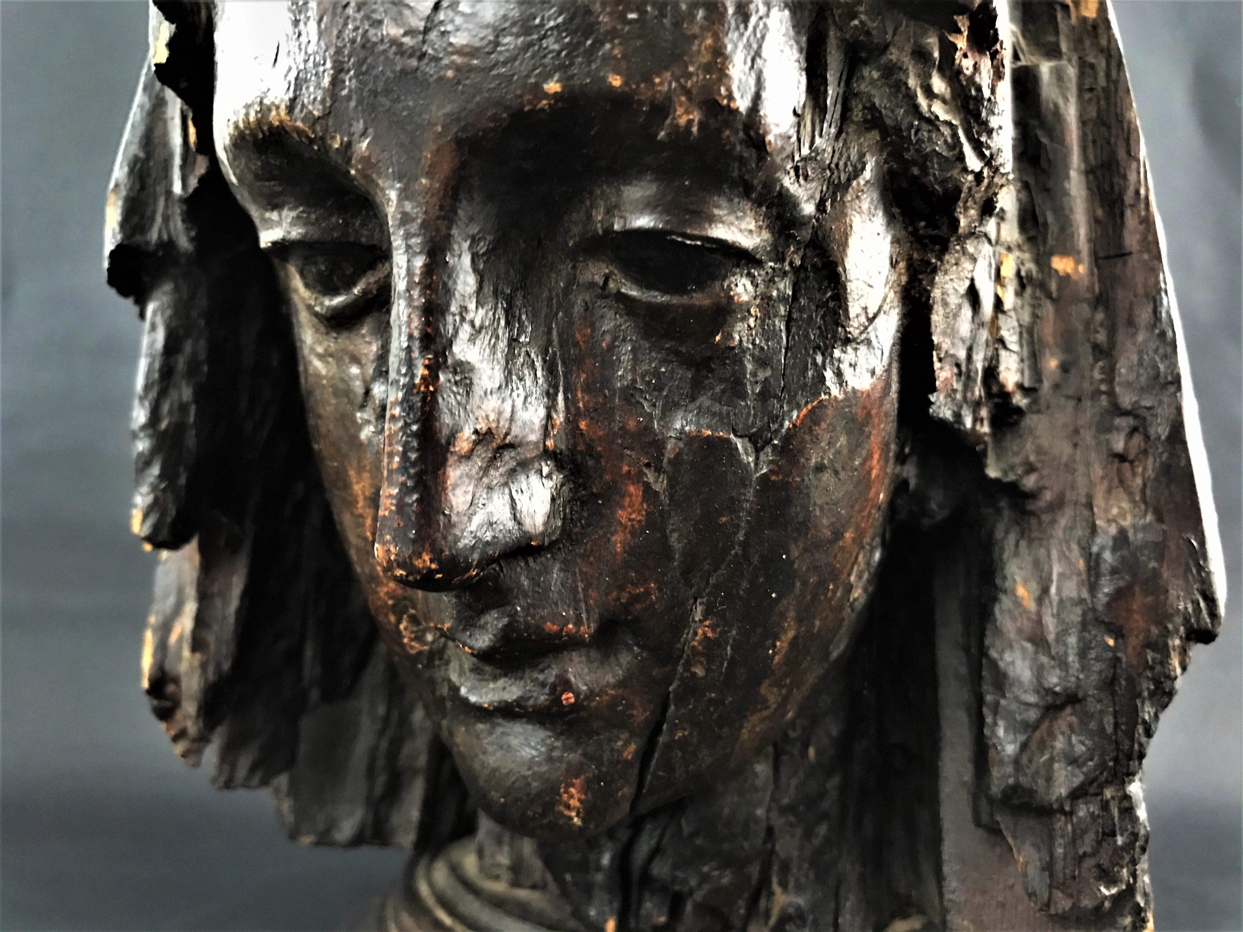 Very beautiful head of a virgin in carved wood and patinated medieval period. It probably comes from a Virgin and Child, probably the rest of the work was burned in a fire. Under the patina redone in the 19th century, one can distinguish remains of