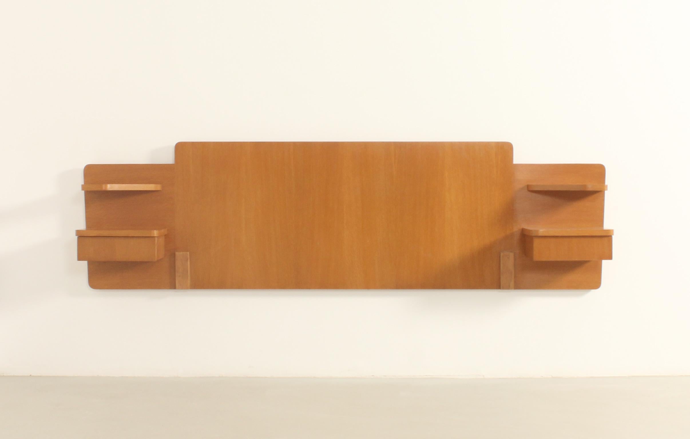Headboard with nightstands in teak wood, France, 1960's. Headboard with two nightstands and two small shelves in veneered teak wood with space for a 135 cm wide bed.