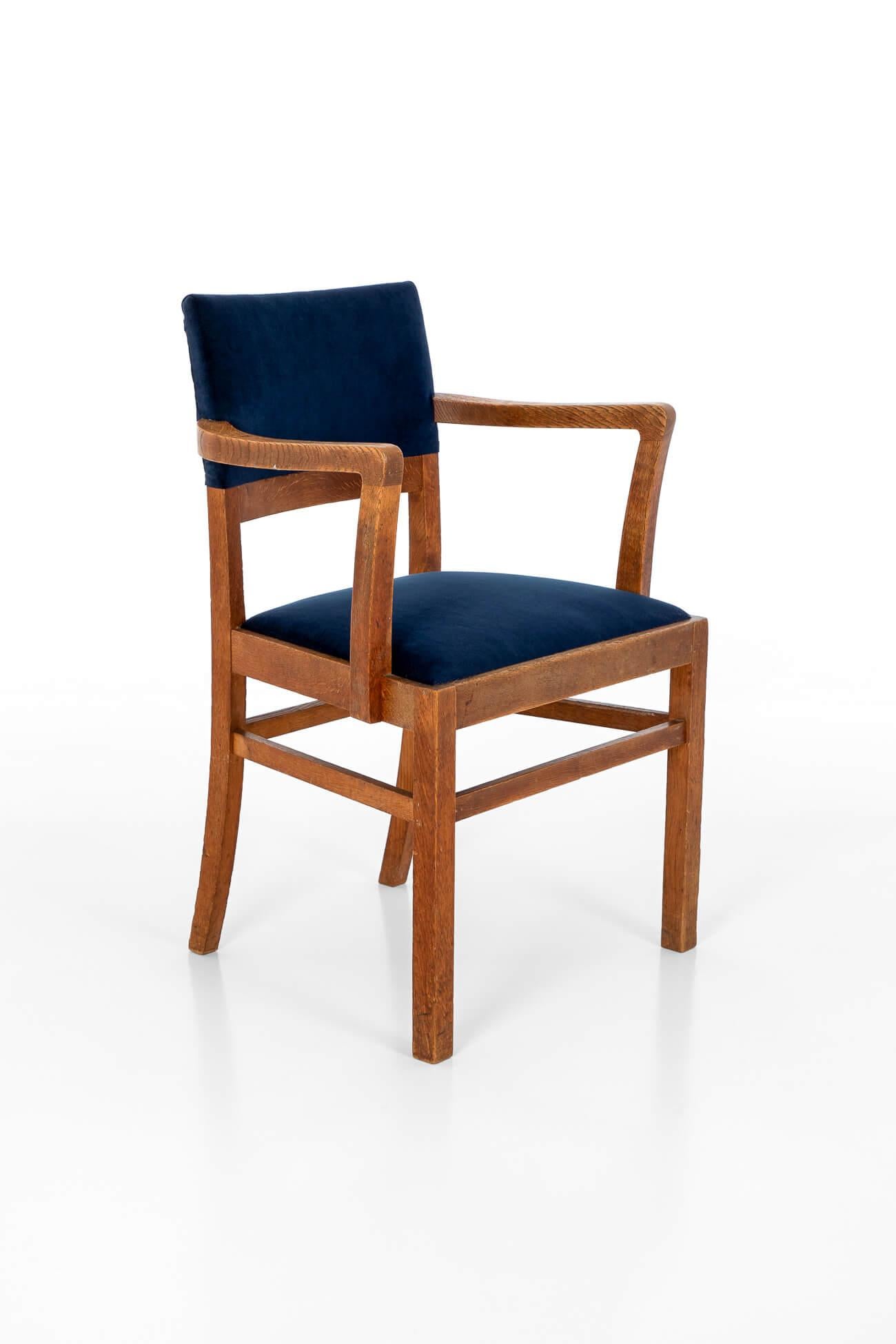 A superb Heal and Son Ltd Arts and Crafts side chair in oak.

High back with curved arms over a generous and comfortable seat cushion. United by peripheral stretchers on both straight saber legs.

The back rest cushion and seat have been