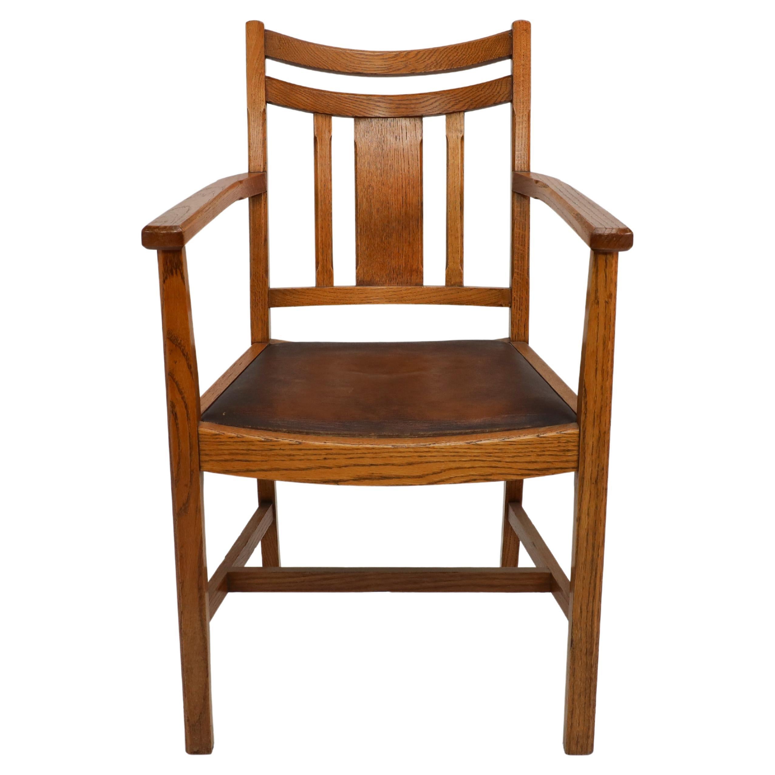 Heals. A good quality Arts and Crafts oak armchair with chamferred details to all the edges and a comfortable shaped seat.