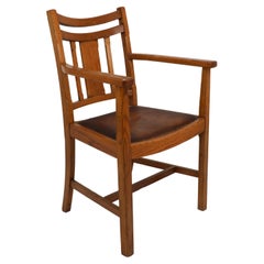 Heal's. Fauteuil en chêne de bonne qualité, de style Arts and Crafts, avec des détails chanfreinés.