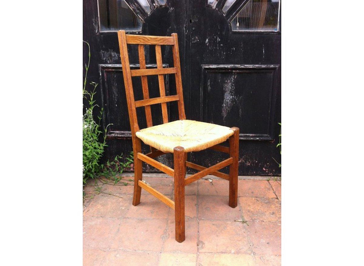 Heals. An Arts & Crafts oak rush seat lattice back side chair.