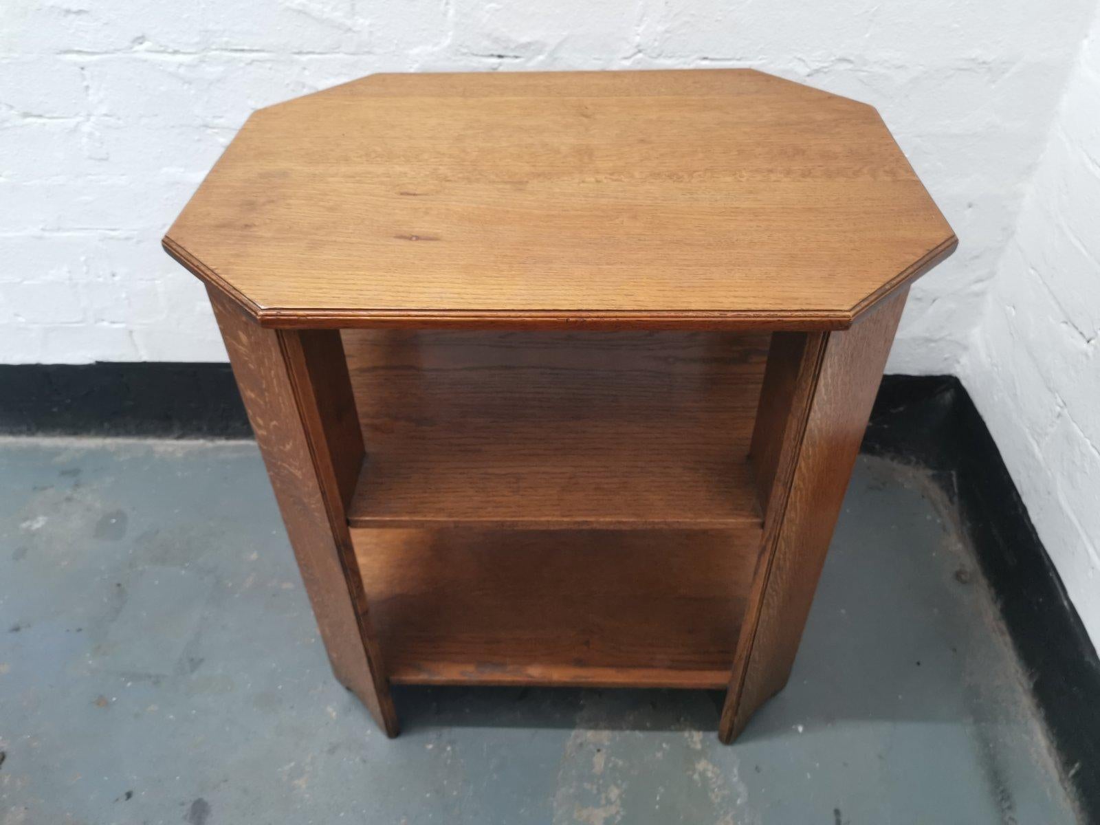 Heals and Son. 
An English Arts and Crafts oak side table with three tiers and canted corners with a nice wild figuring to the grain.