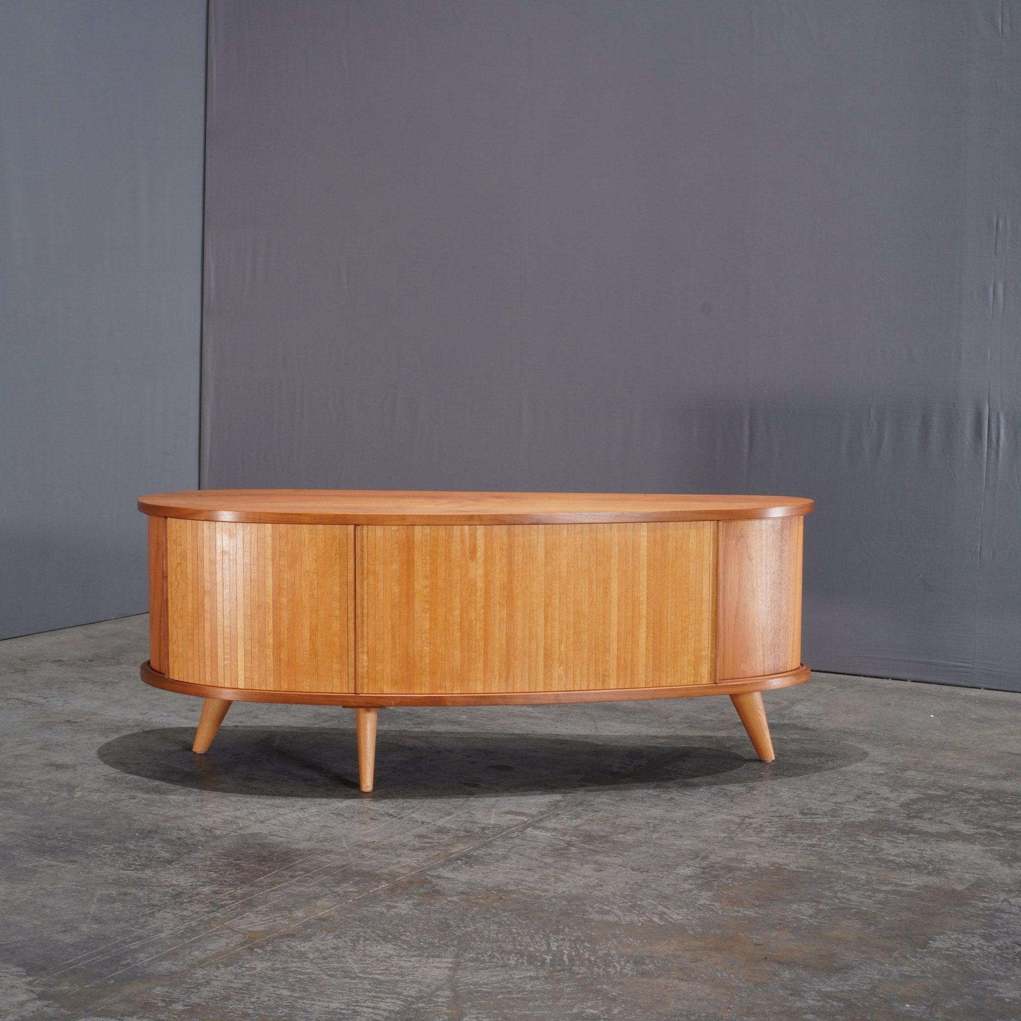 The Heal's Flow Sideboard by Kay + Stemmer is a beautifully crafted piece that embodies mid-century modern aesthetics with a contemporary twist. Designed with clean lines and a minimalist silhouette, this sideboard features a solid wood construction
