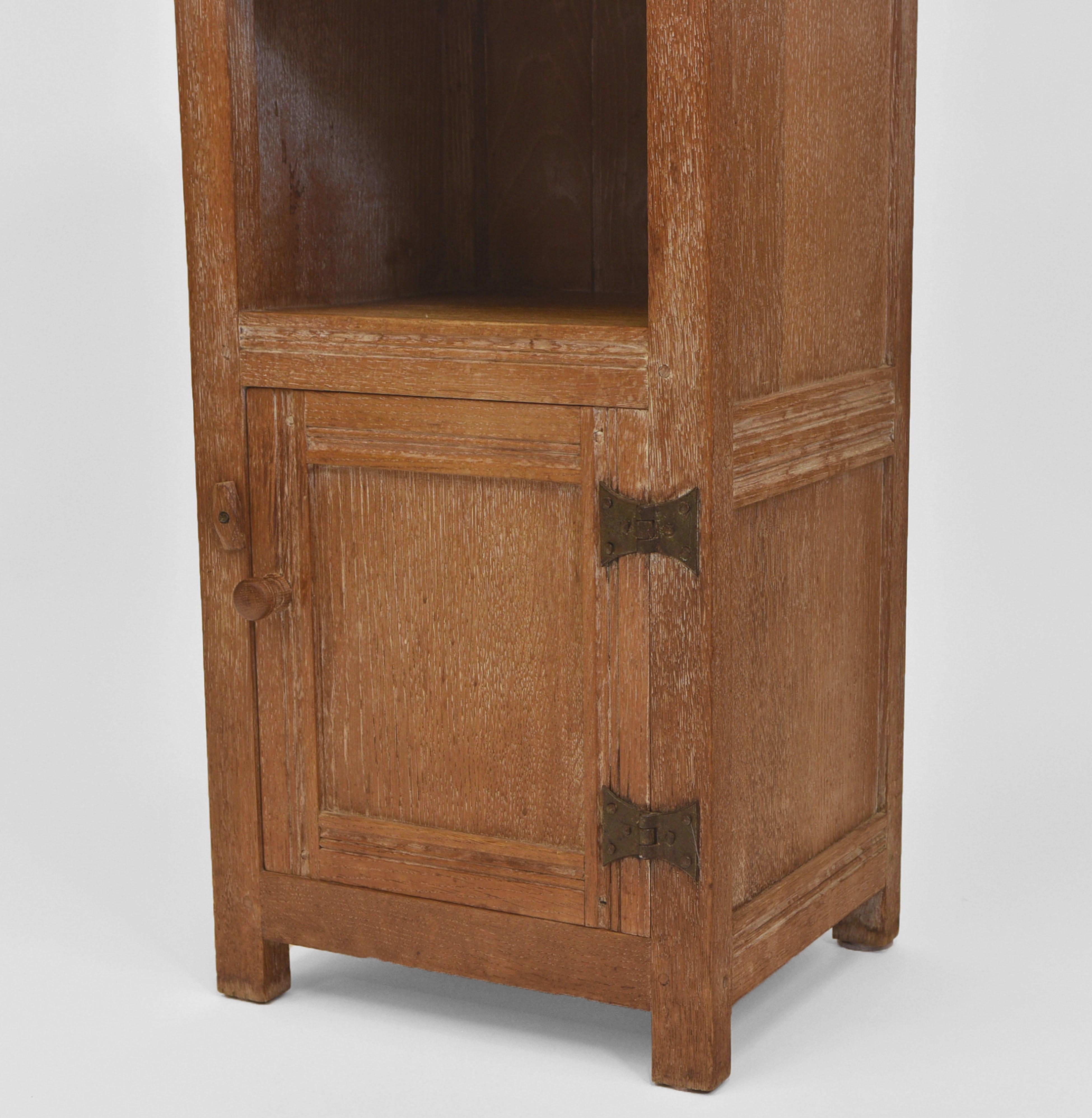 Limed oak bedside cabinet by Heal & Son. Circa late 1930's.

Superbly made, with each join having dowel construction, forged iron exposed cabinet door hinges. Made in solid oak with inner fielded sides and door panel. The back is tongue and grooved
