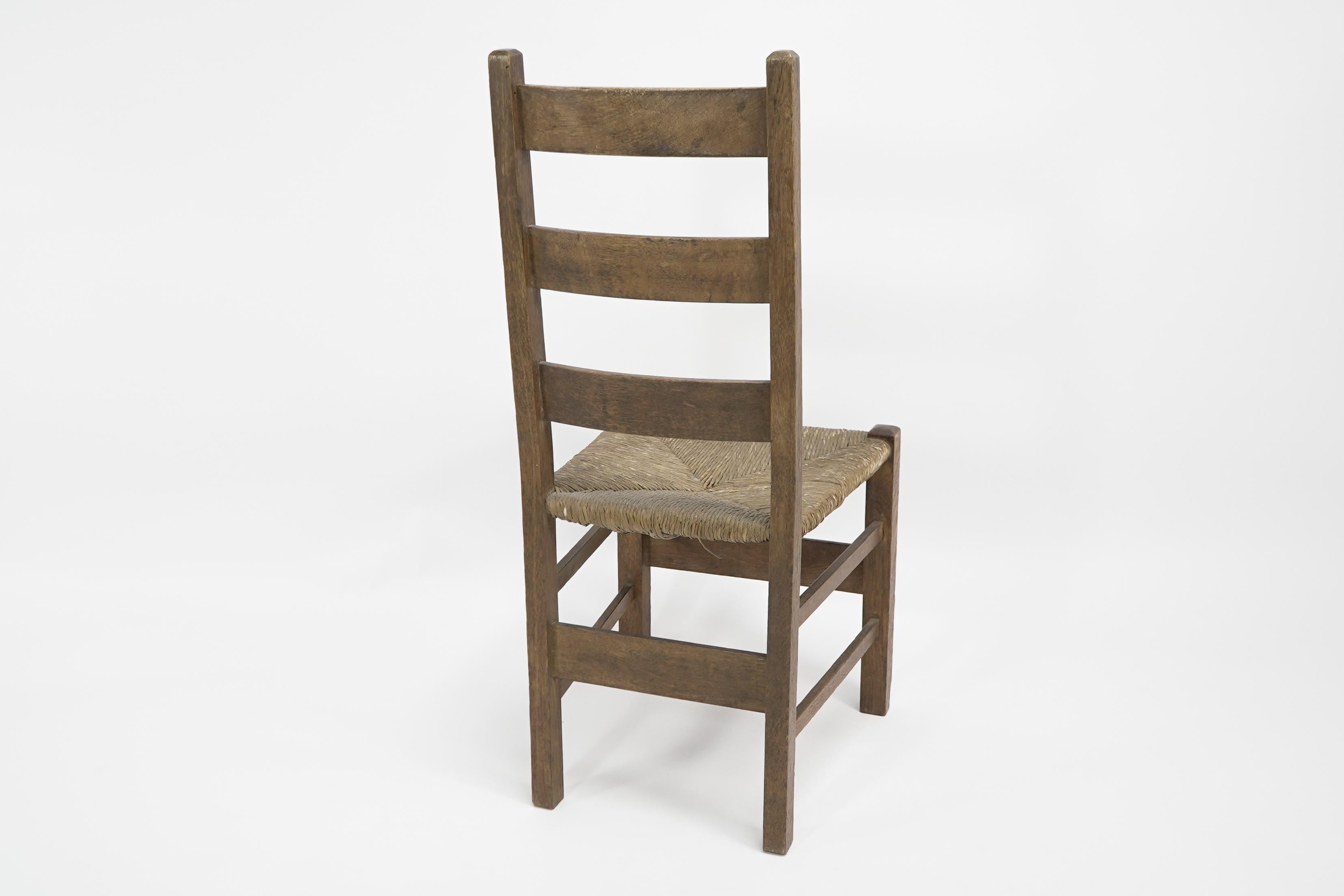 English Heals. London. An Arts and Crafts ladderback with original rush seat For Sale