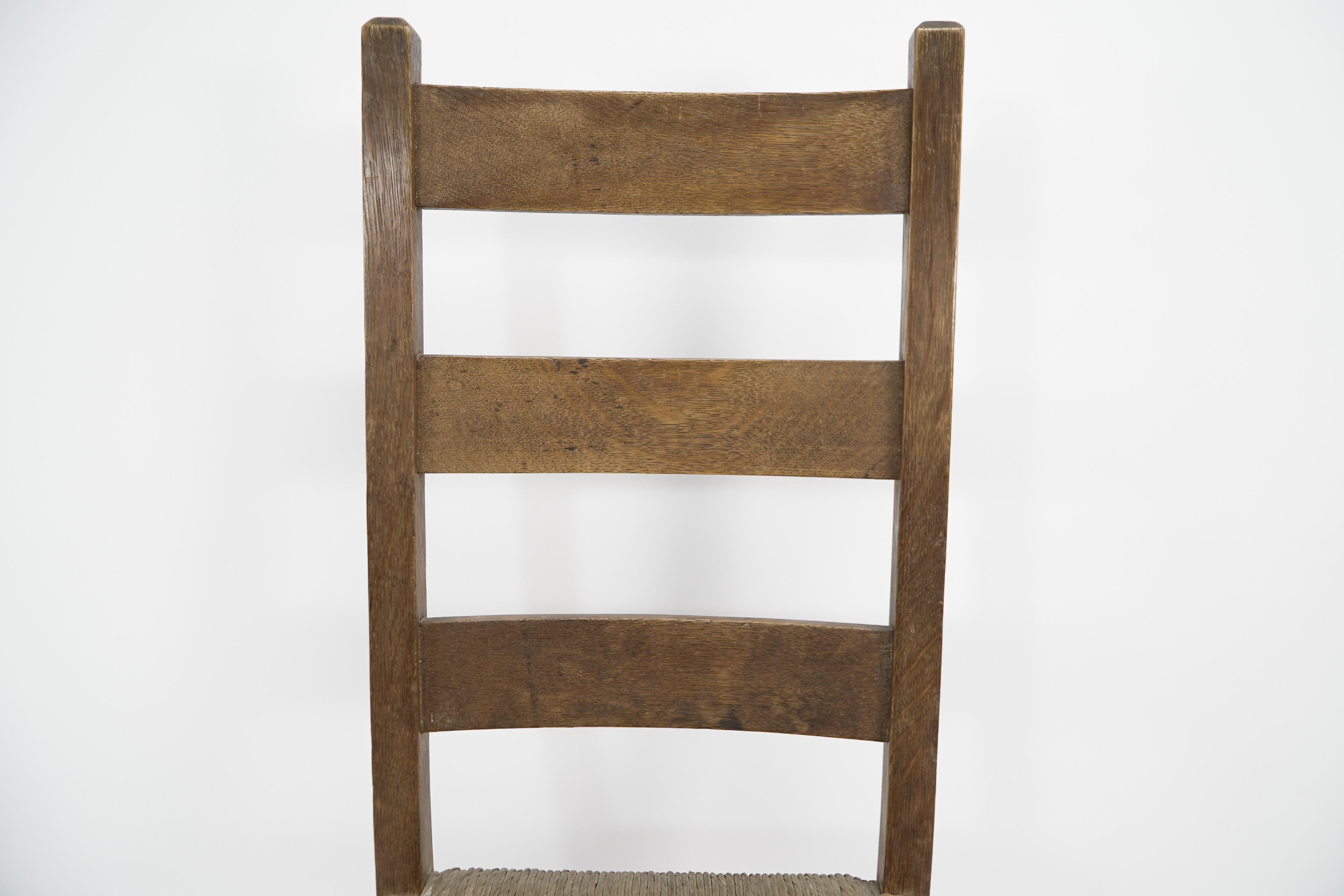 Oak Heals. London. An Arts and Crafts ladderback with original rush seat For Sale