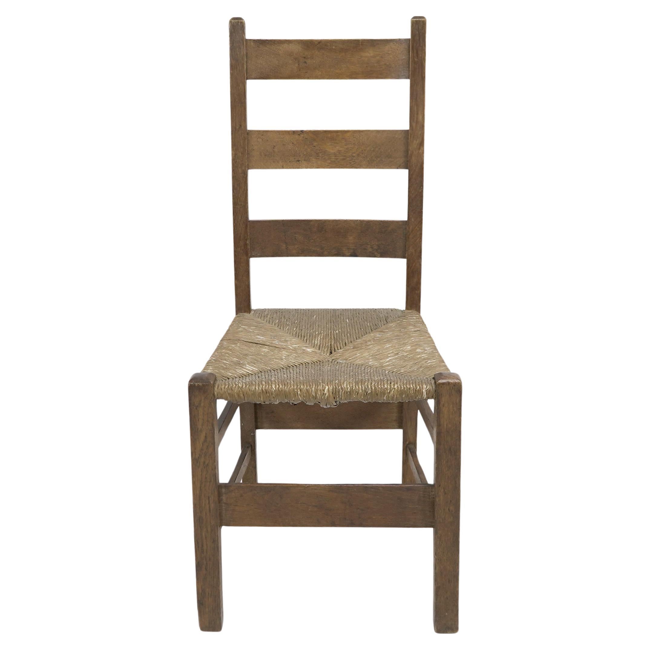 Heals. London. An Arts and Crafts ladderback with original rush seat For Sale