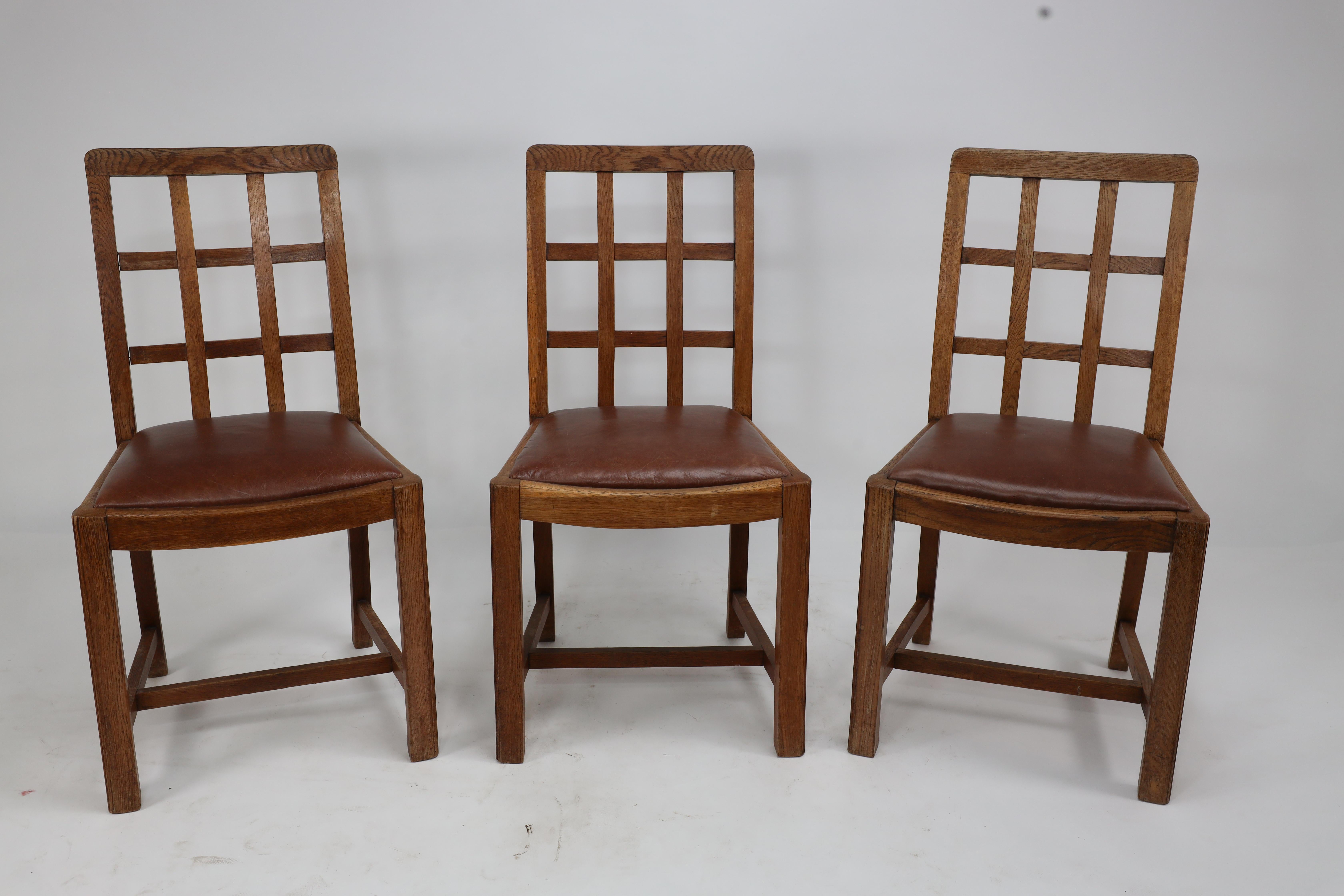 Heals of London, attribué. Ensemble de quatre fauteuils en chêne à dossier en treillis de style Arts and Crafts
