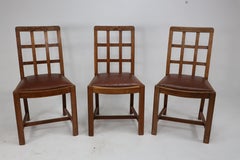 Heals of London, attri. A set of four Arts and Crafts Lattice back oak armchairs