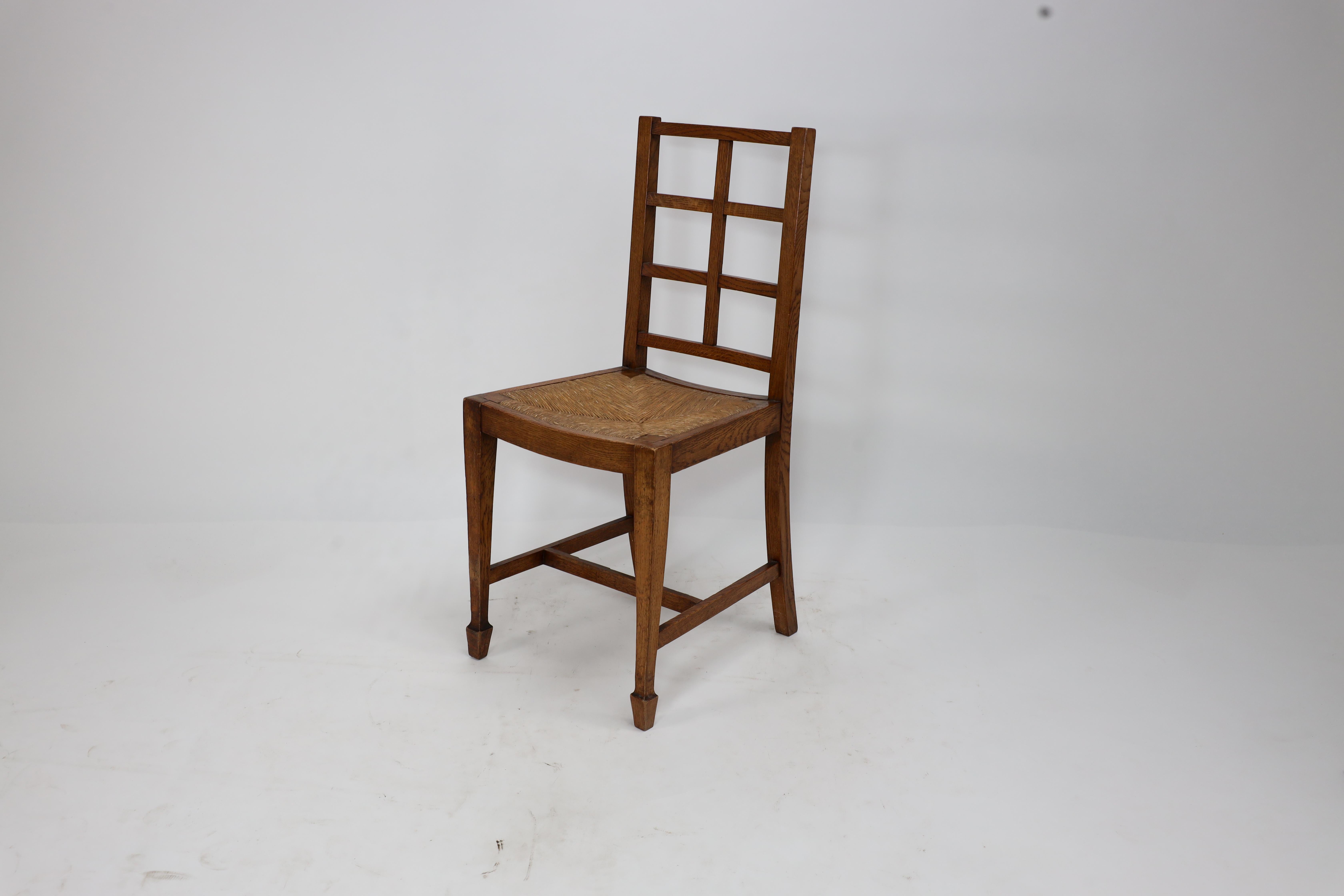 Arts and Crafts Heals of London, attributed. An Arts & Crafts oak lattice back side chair For Sale
