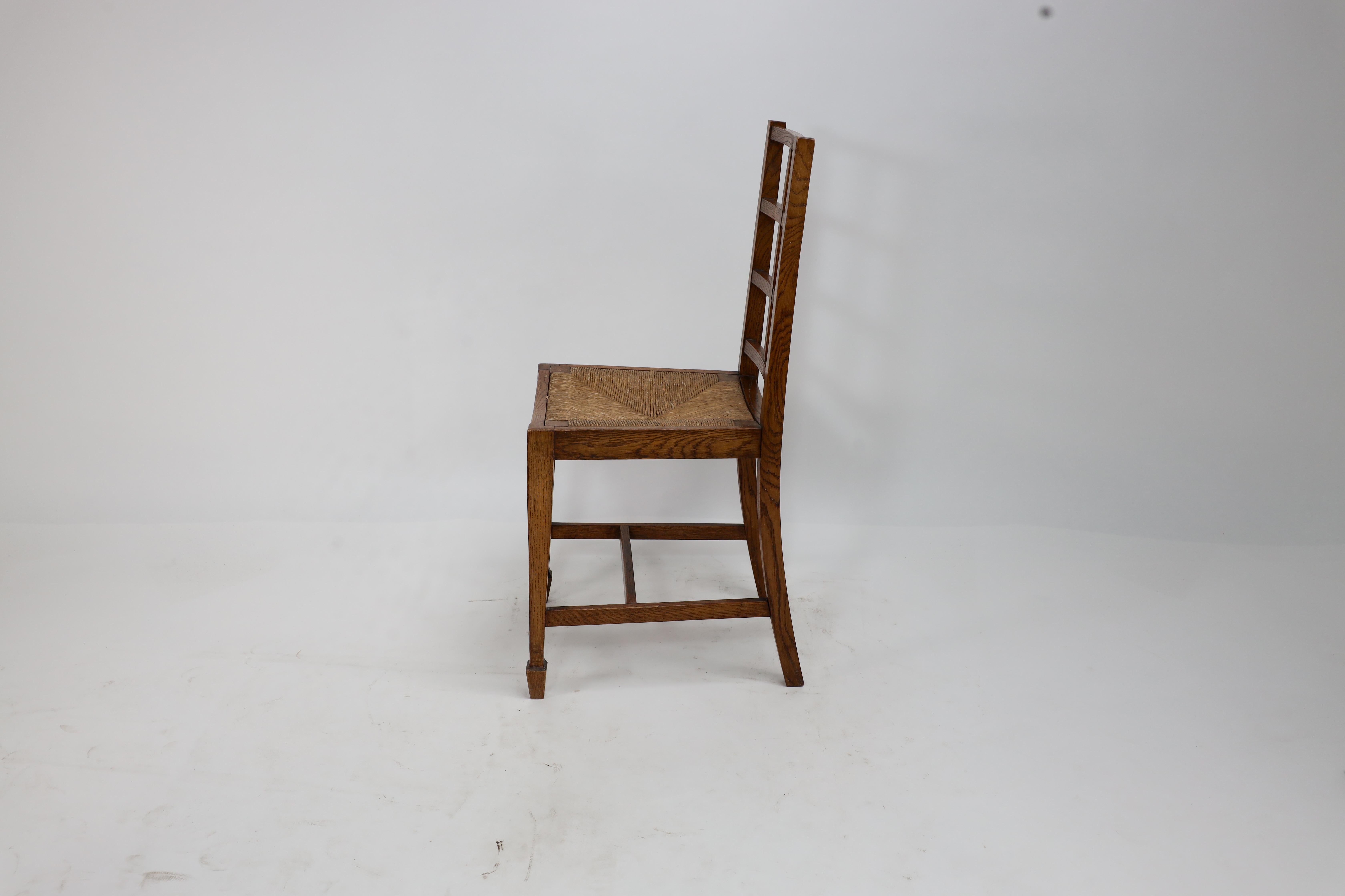 English Heals of London, attributed. An Arts & Crafts oak lattice back side chair For Sale