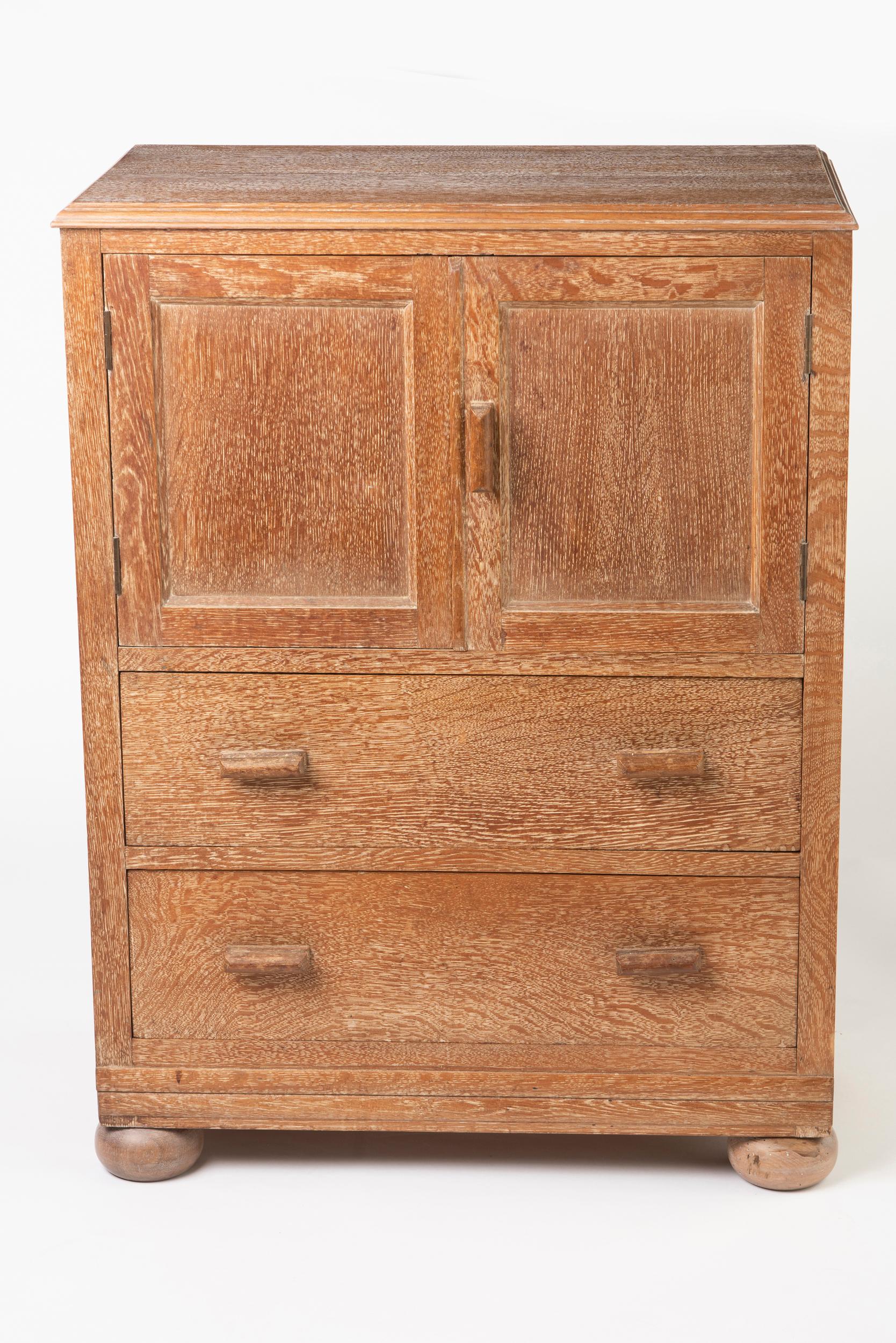 A cabinet by Heals of London.
Limed oak.
Of rectangular form.
Double cupboard above two drawers. Bun feet.
England, circa 1920
Measures: 92 cm high x 69 cm wide x 41 cm deep.