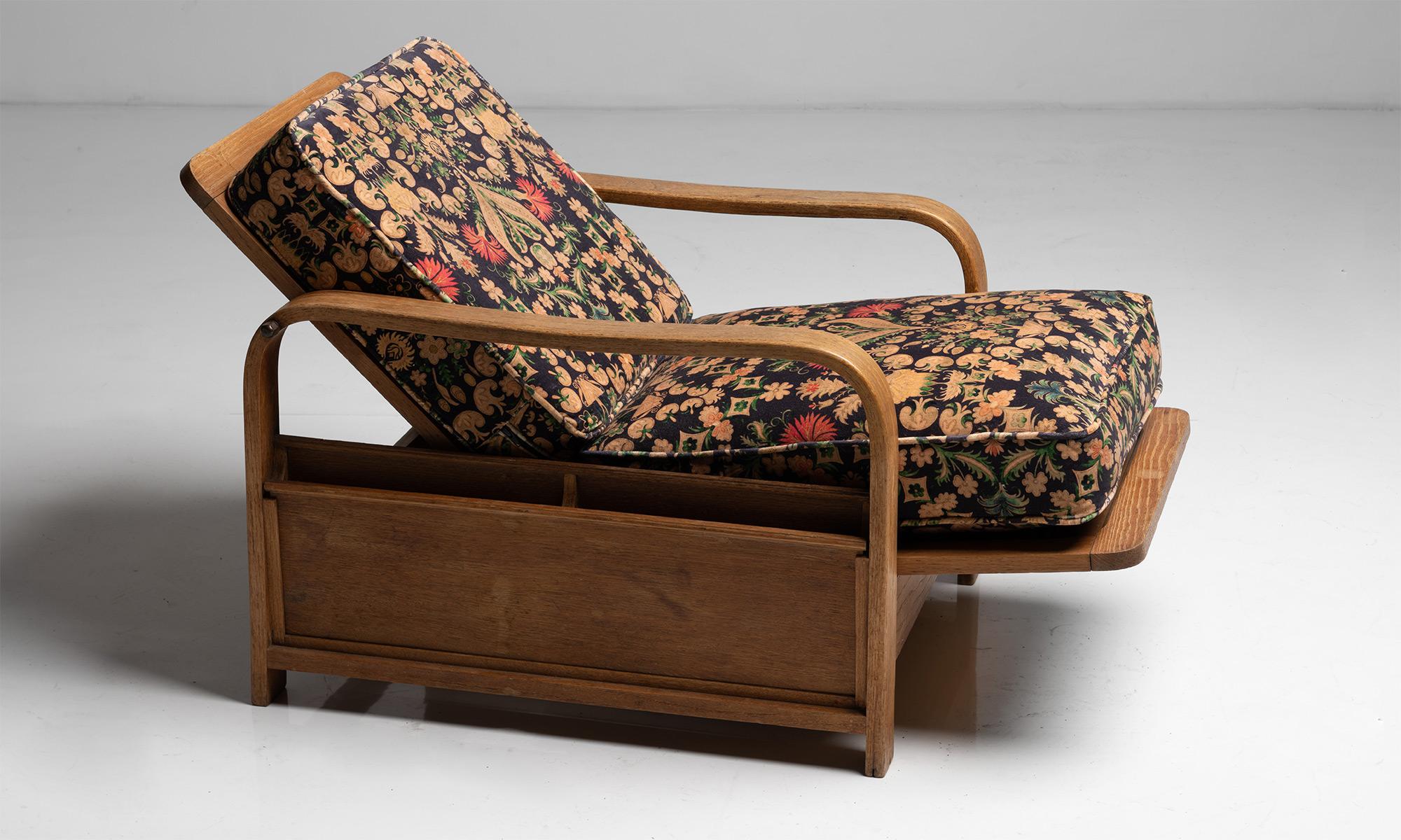 Heals of London oak reading chair in artio velvet by House of Hackney

England Circa 1920

Newly upholstered, with reclining backrest and magazine racks on each side.

Measures: 24.5”L x 33”D / 46”D extended x 30.75”H x 17.5”seat.