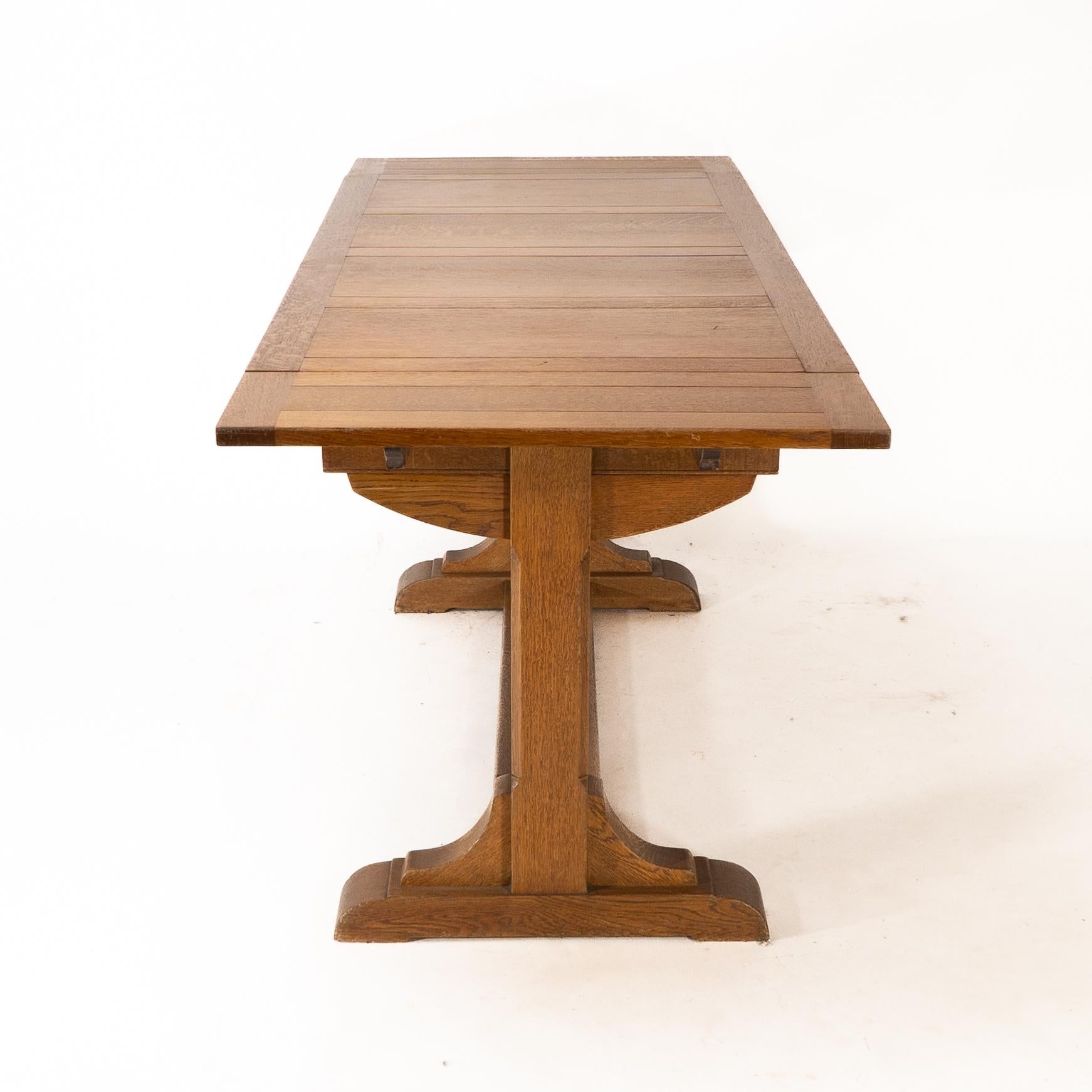 English Heals & Son. An Arts & Crafts narrow oak extending dining table For Sale