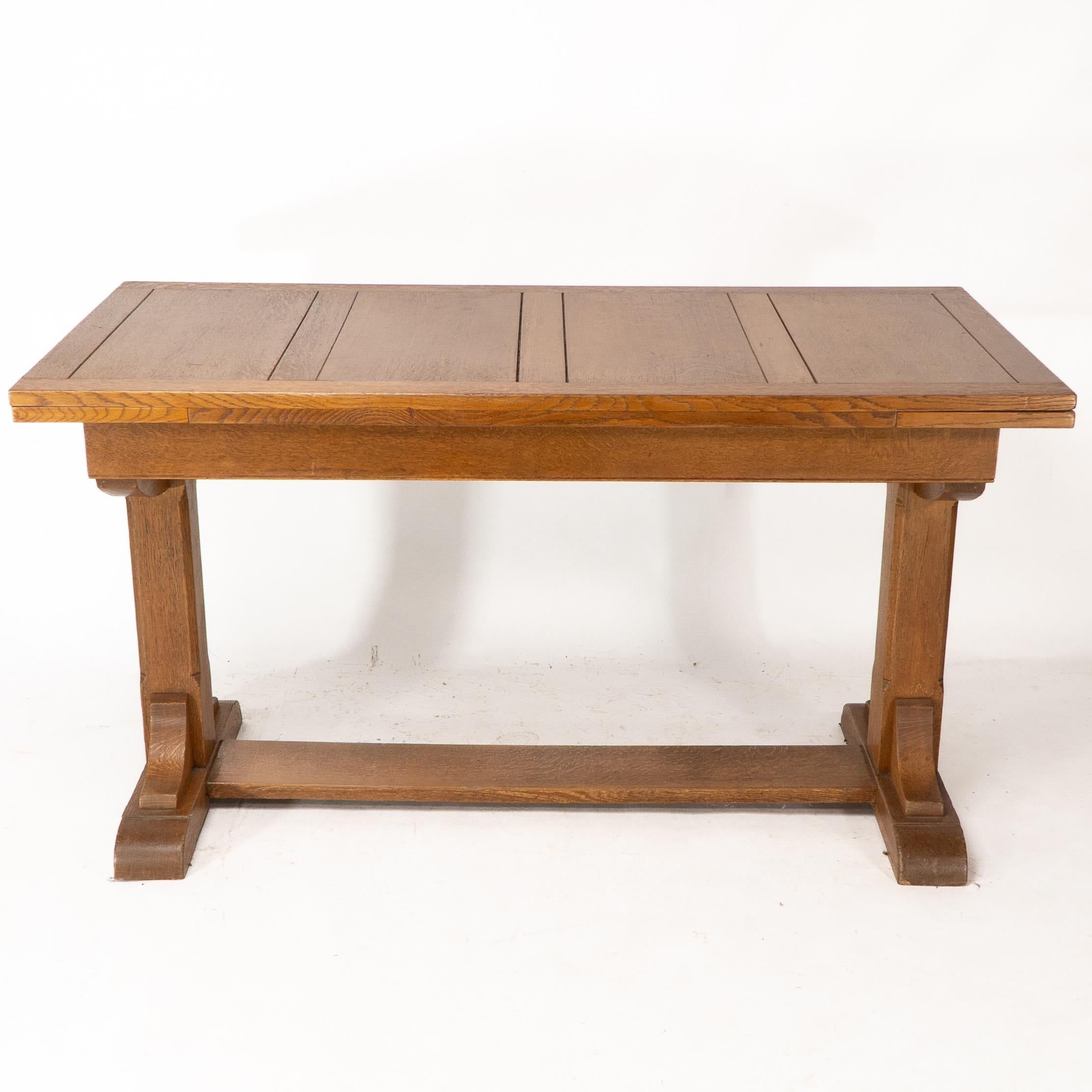 Heals & Son. An Arts & Crafts narrow oak extending dining table In Good Condition For Sale In London, GB