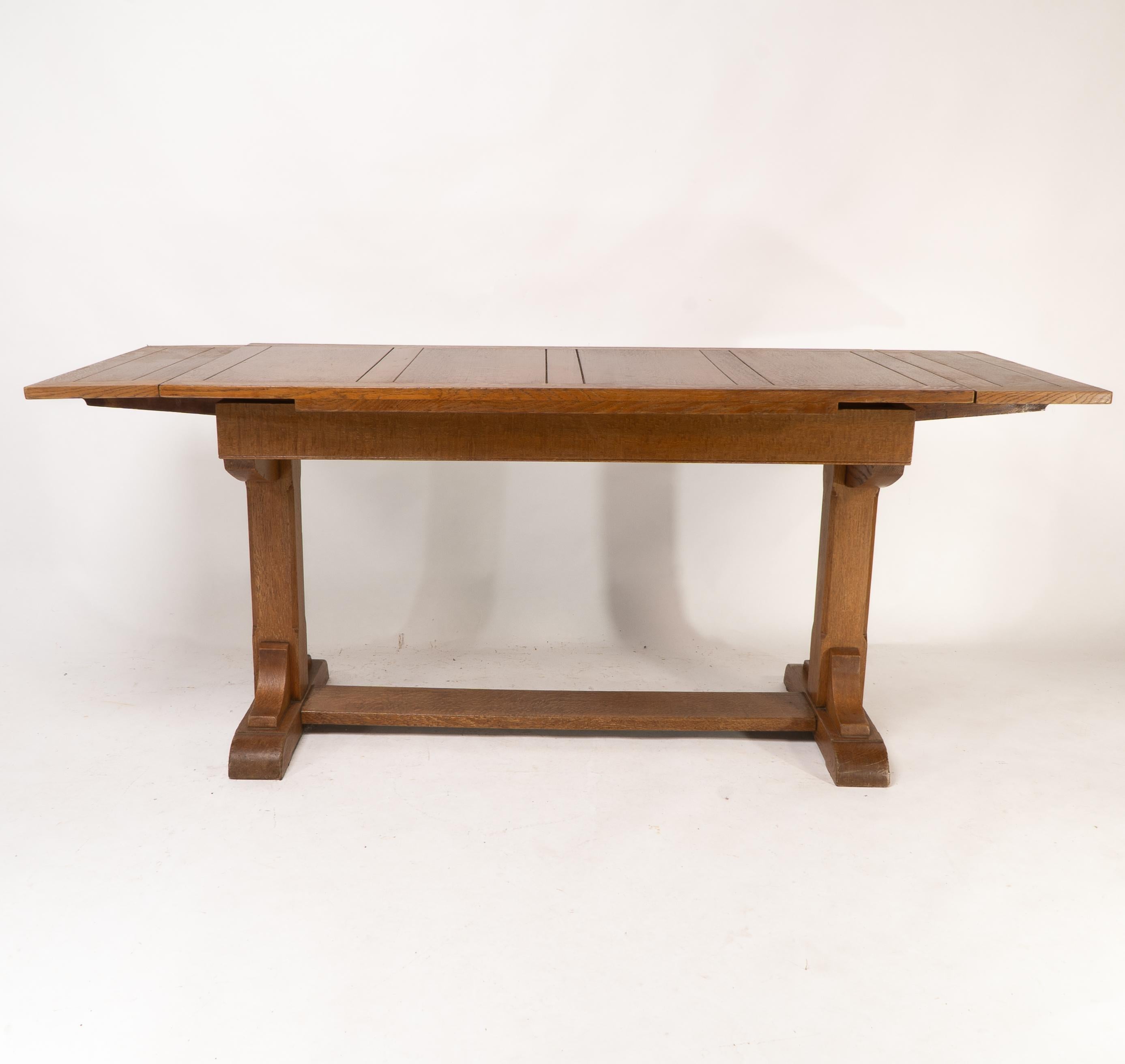 Early 20th Century Heals & Son. An Arts & Crafts narrow oak extending dining table For Sale
