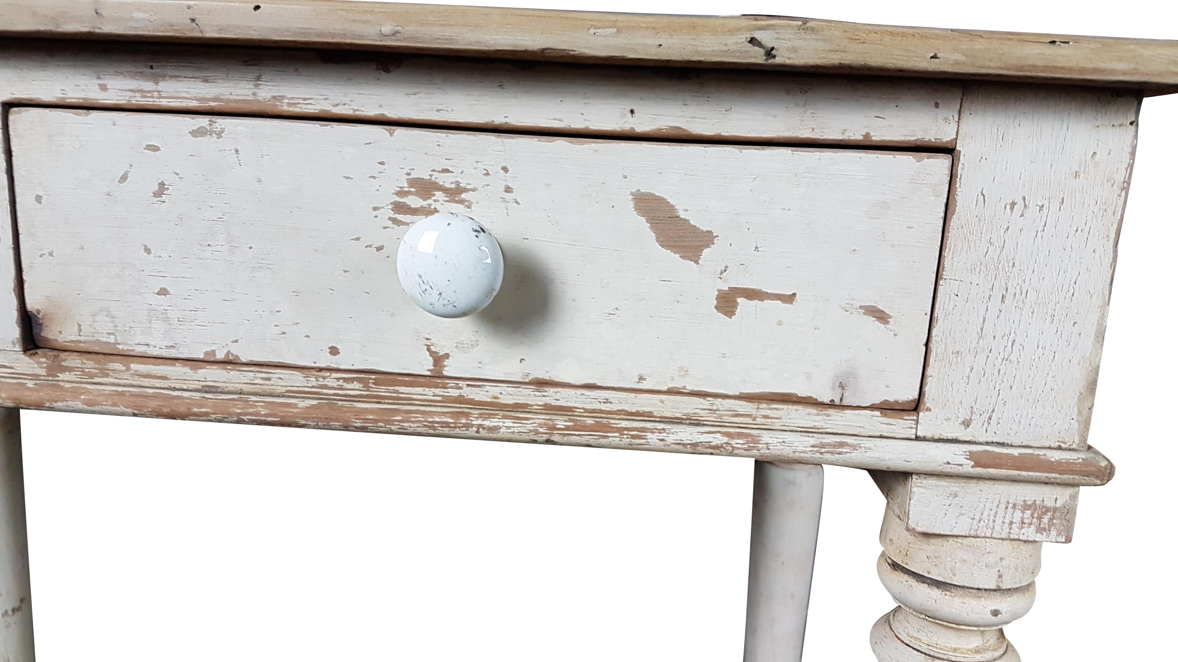 A nice side table by Heals & Sons of London, it has been carefully taken back to its original painted finish. The table sits on four white porcelain castors and has the two original porcelain handles although one is chipped. The top has been