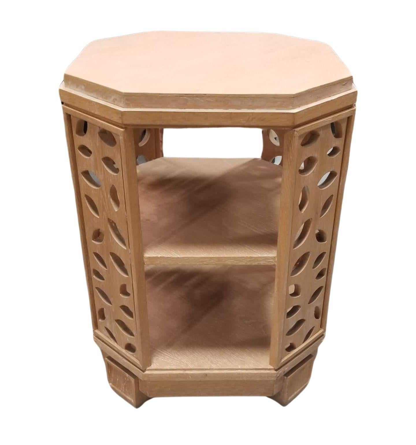 This distinctive octagonal side table, crafted from light wood, features charming botanical leaf-shaped cut-out side panels, adding a touch of nature-inspired elegance to your space. With two inner shelves, it combines form and function