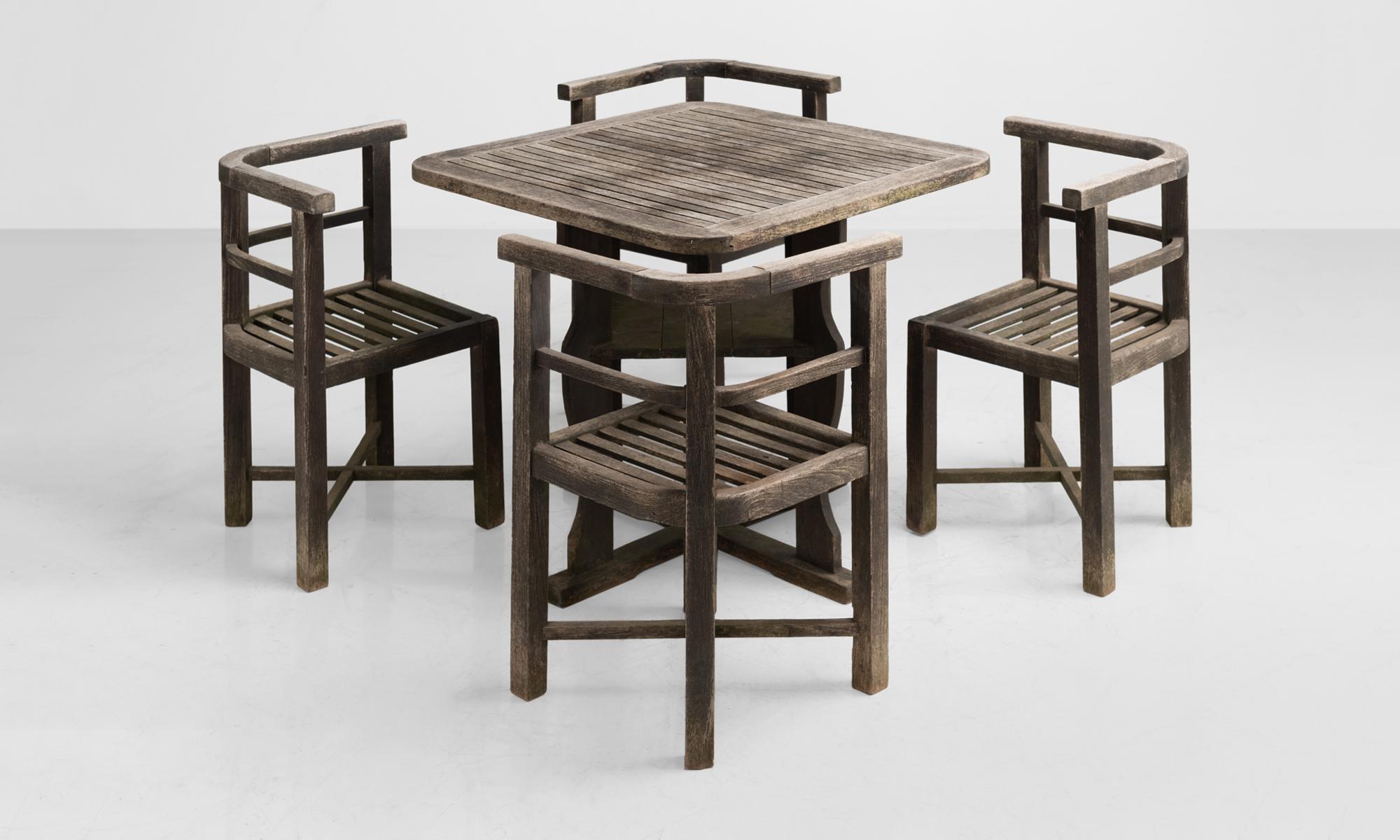 Heal's teak garden set, circa 1930.

Slatted tabletop on vase shaped legs, with four corner chairs.