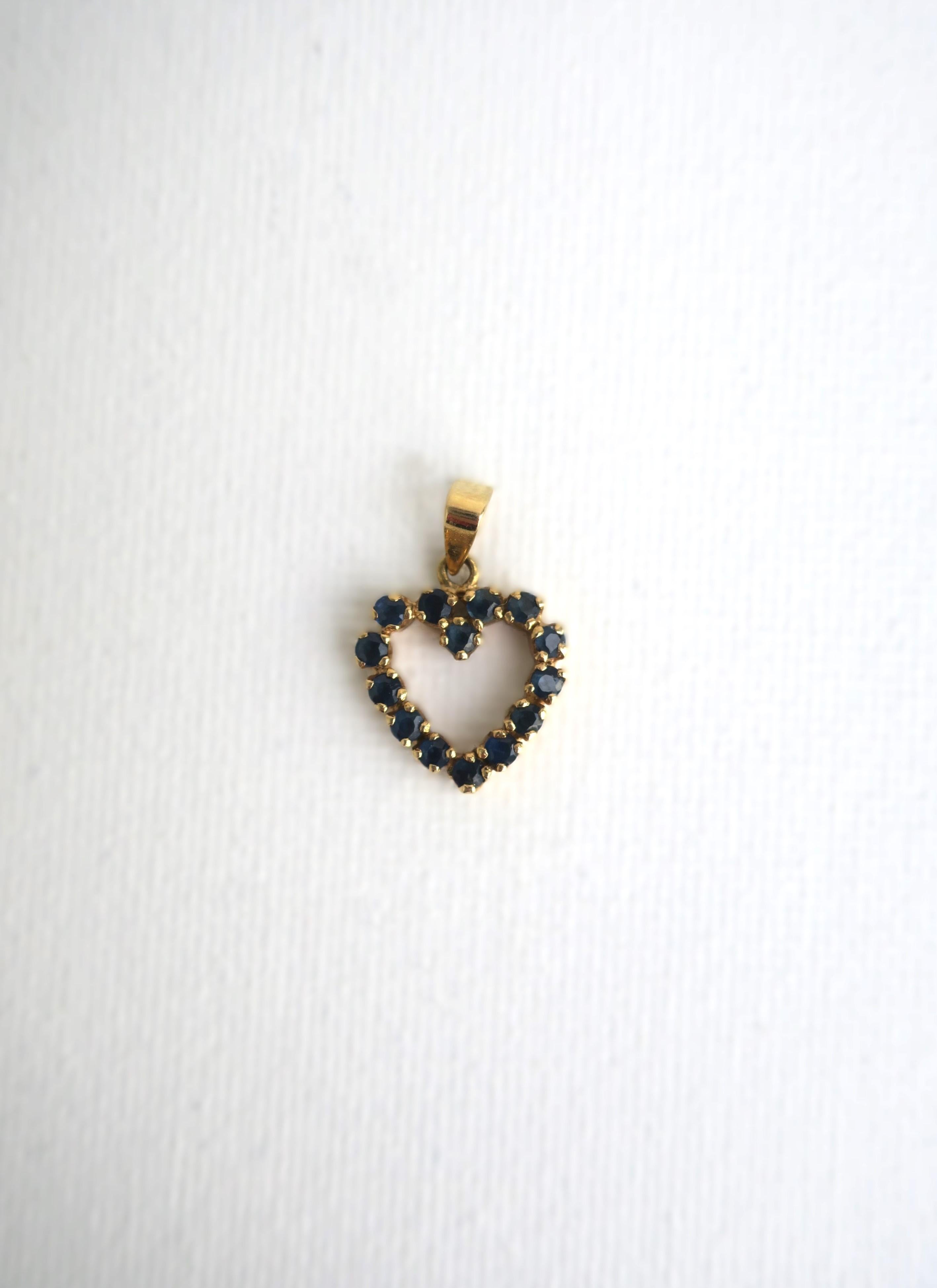 Ciondolo a cuore in zaffiri blu e oro giallo 14 carati, circa fine XX secolo. Ciondolo a cuore con zaffiri blu incastonati in oro giallo 14 carati, con marchio in oro sul retro del cappio/bilanciere, 