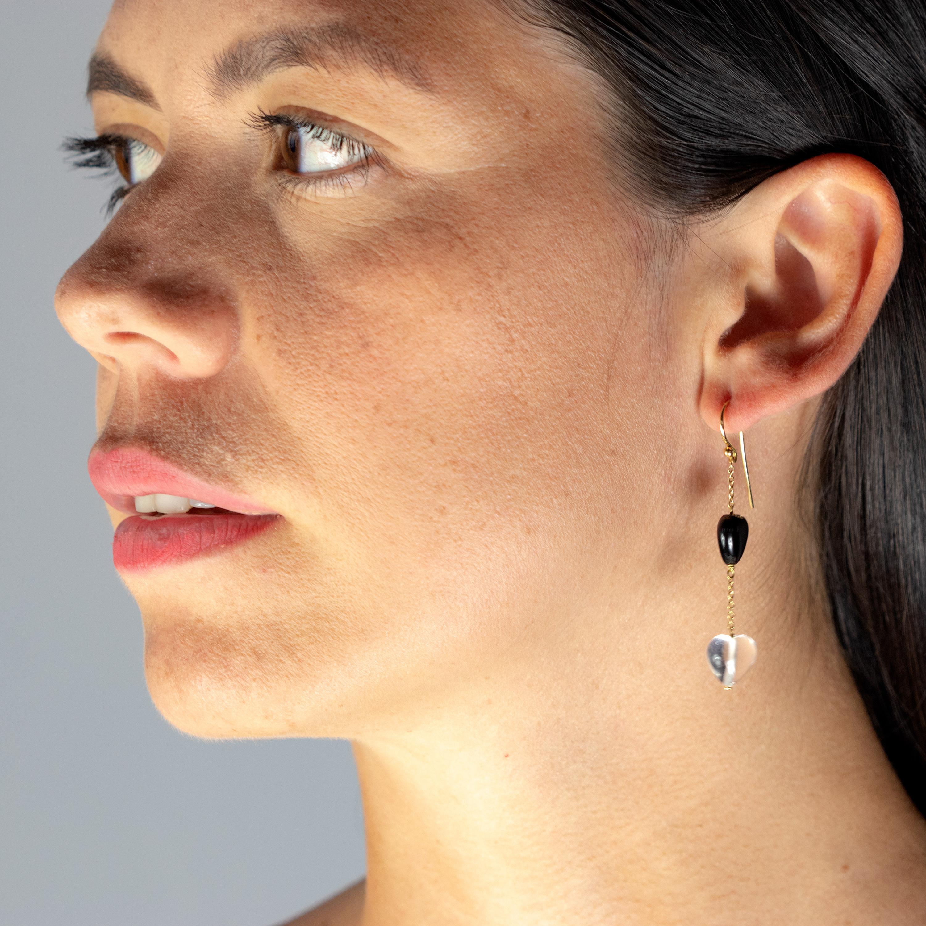 Ces merveilleuses boucles d'oreilles pendantes en fil d'oreille faites à la main sont composées des pierres les plus précieuses. Une paire de cristal de roche en forme de cœur et une paire d'agate noire qui créent l'illusion d'un look asymétrique et