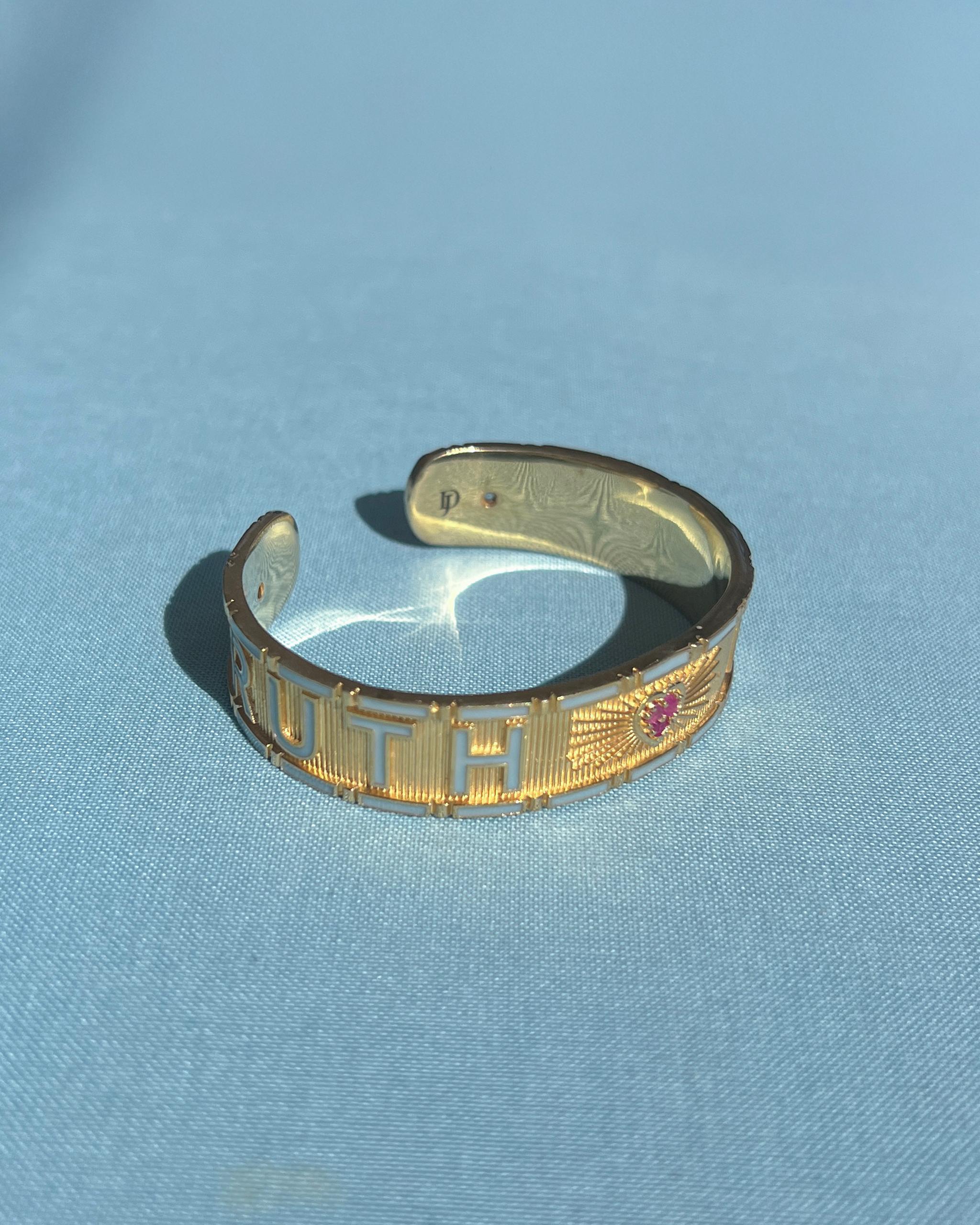 Ruby Heart Cuff Bracelet with Diamonds and Light Blue Enamel – “Truth & Faith” by J Dauphin

The Truth & Faith cuff bracelet by J Dauphin merges sacred symbolism with sculptural refinement. Handcrafted in 14k gold-plated brass, this open statement