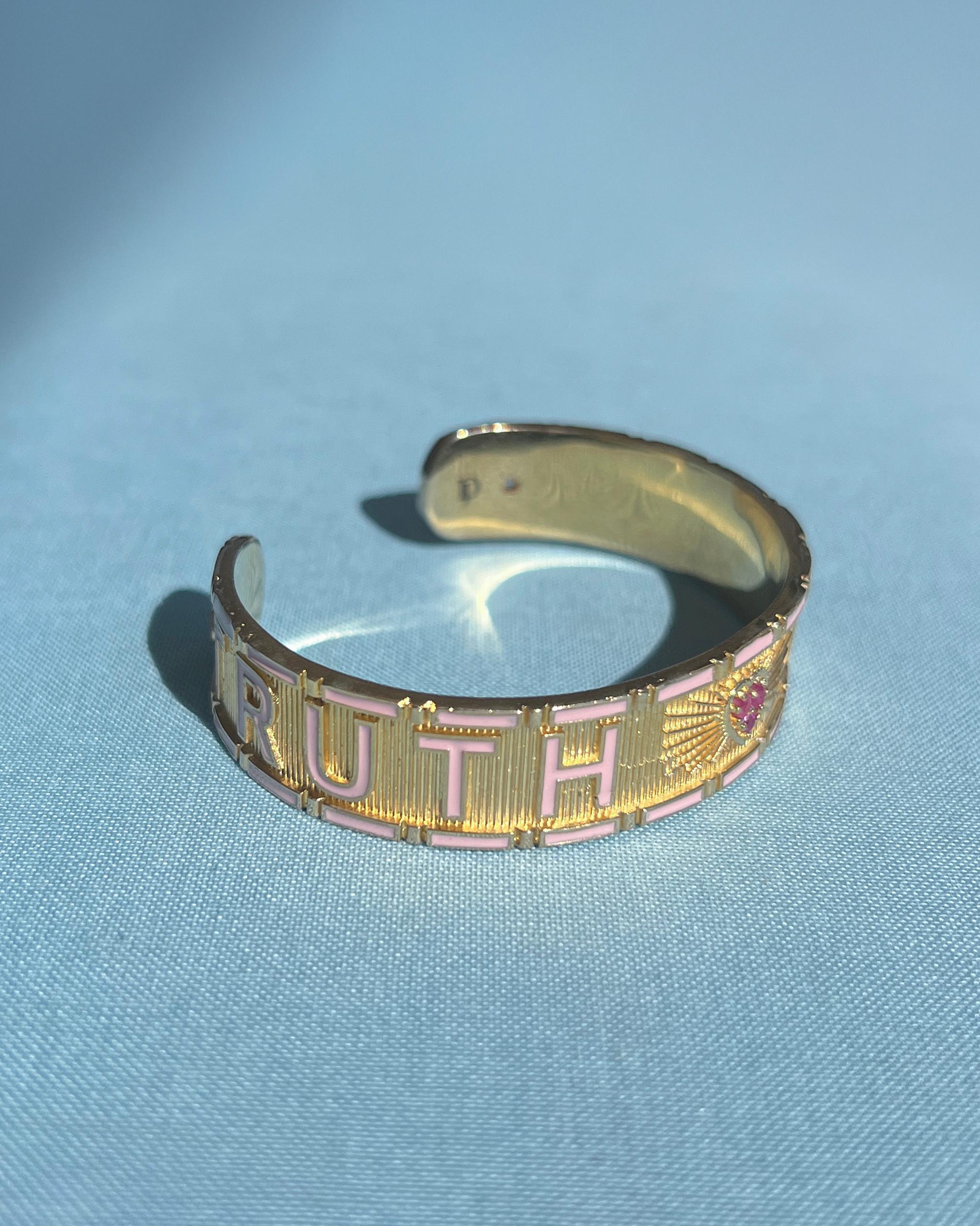 Ruby Heart Cuff Bracelet with Diamonds and Light Pink Enamel – “Truth & Faith” by J Dauphin

The Truth & Faith cuff bracelet by J Dauphin merges sacred symbolism with sculptural refinement. Handcrafted in 14k gold-plated brass, this open statement