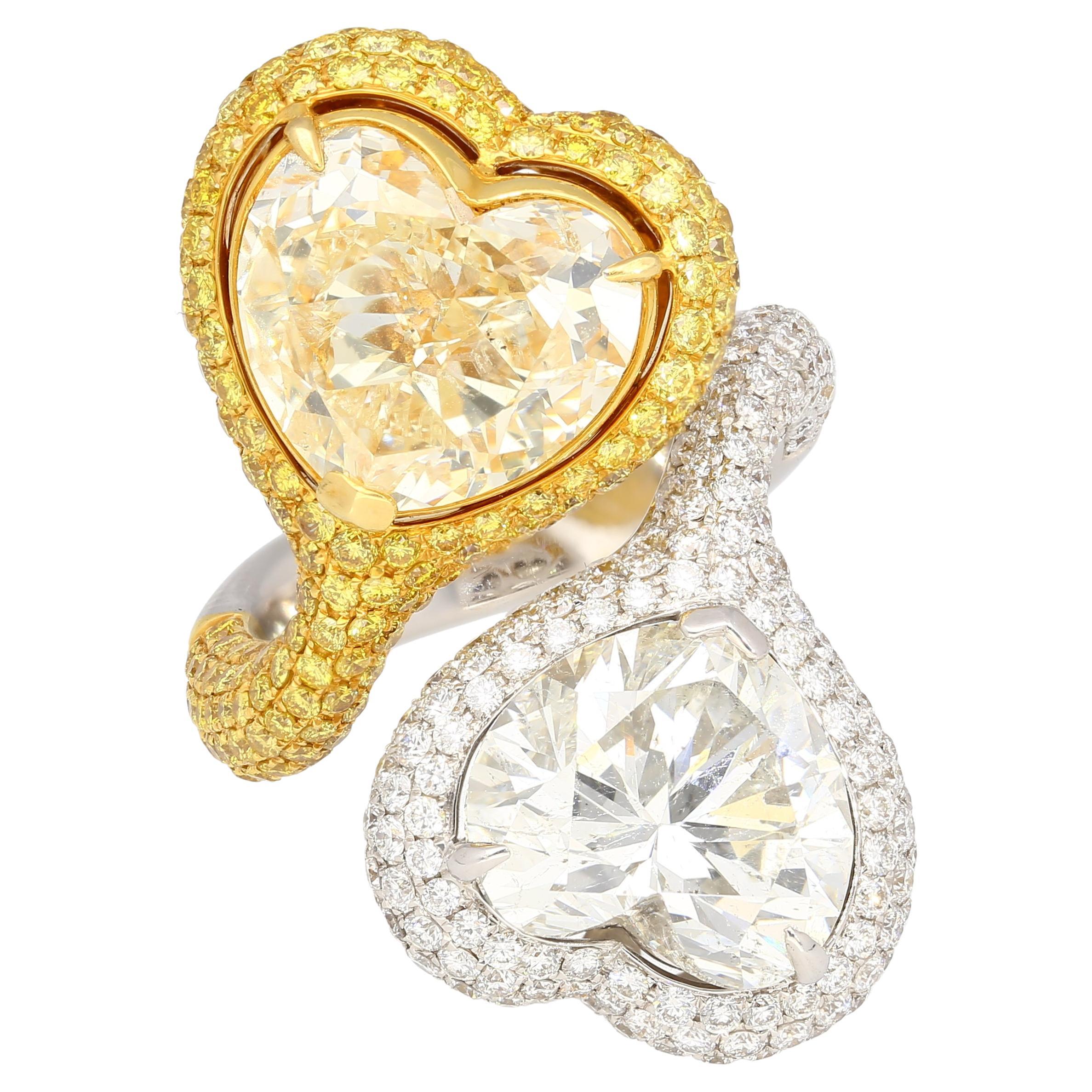 18K two-tone Toi Et Moi ring, weighing 16.57 grams. Featuring two heart-cut diamonds; 5.79ct G/SI2 with EGL #EGL6302103318, and 5.73ct Fancy Yellow with SI2 clarity. Adorned by 192 Round-cut yellow diamonds of 1.57cttw and 191 Round-cut white