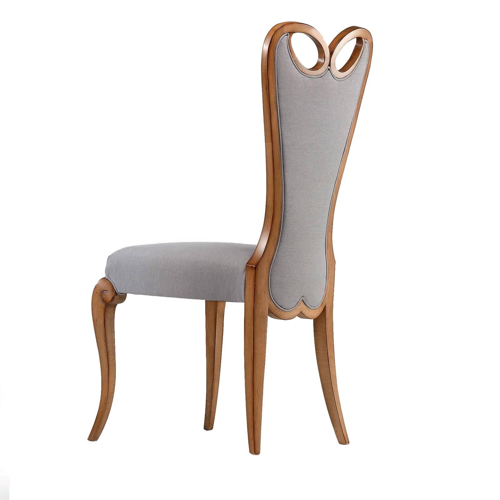 A modern take on a classic French-Baroque style, this chair merges comfort with style. Characterized by flowing lines, the wooden frame is upholstered with a light grey soft fabric on the back and seat cushion. The tall backrest boasts a heart-shape