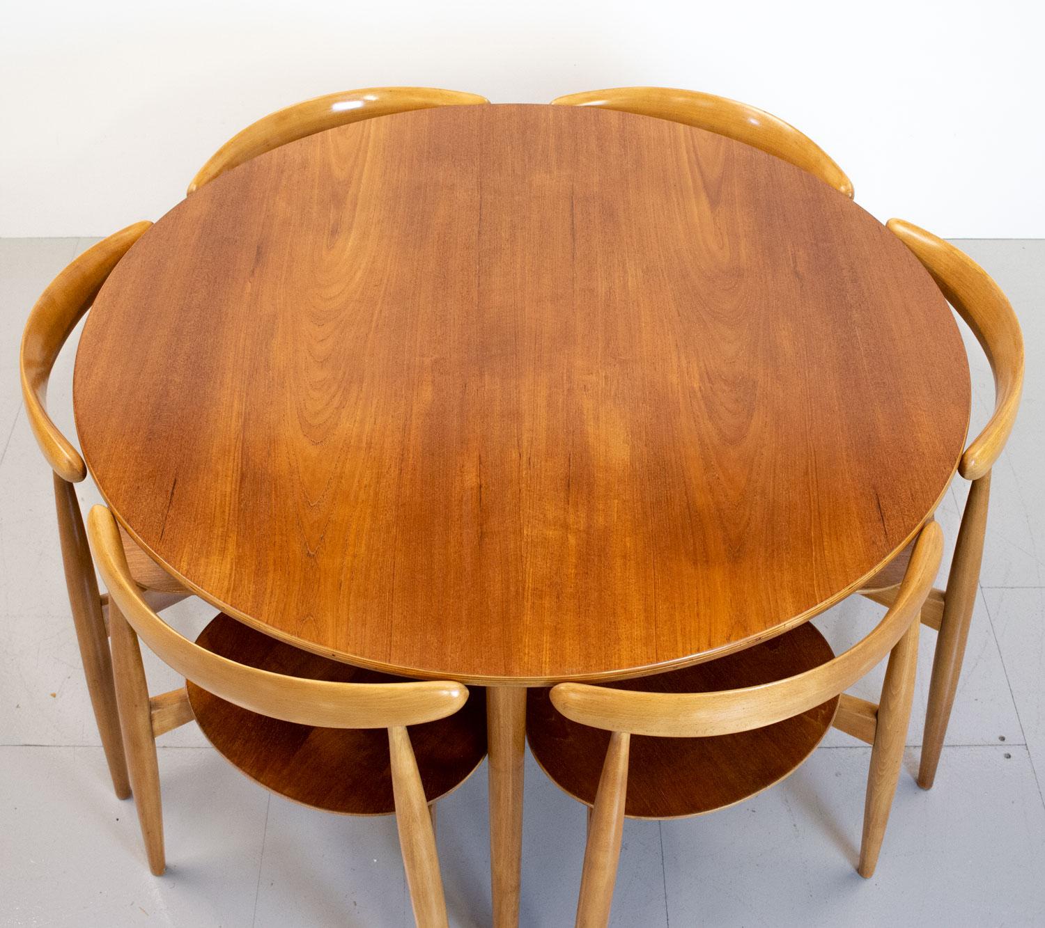 An iconic dining set comprising 6 model FH4103 Heart stacking chairs, named after the heart shape of the seat, and a model FH4602 table designed by Hans J. Wegner for Danish company Fritz Hansen in 1953. All constructed with tripod beech frames and
