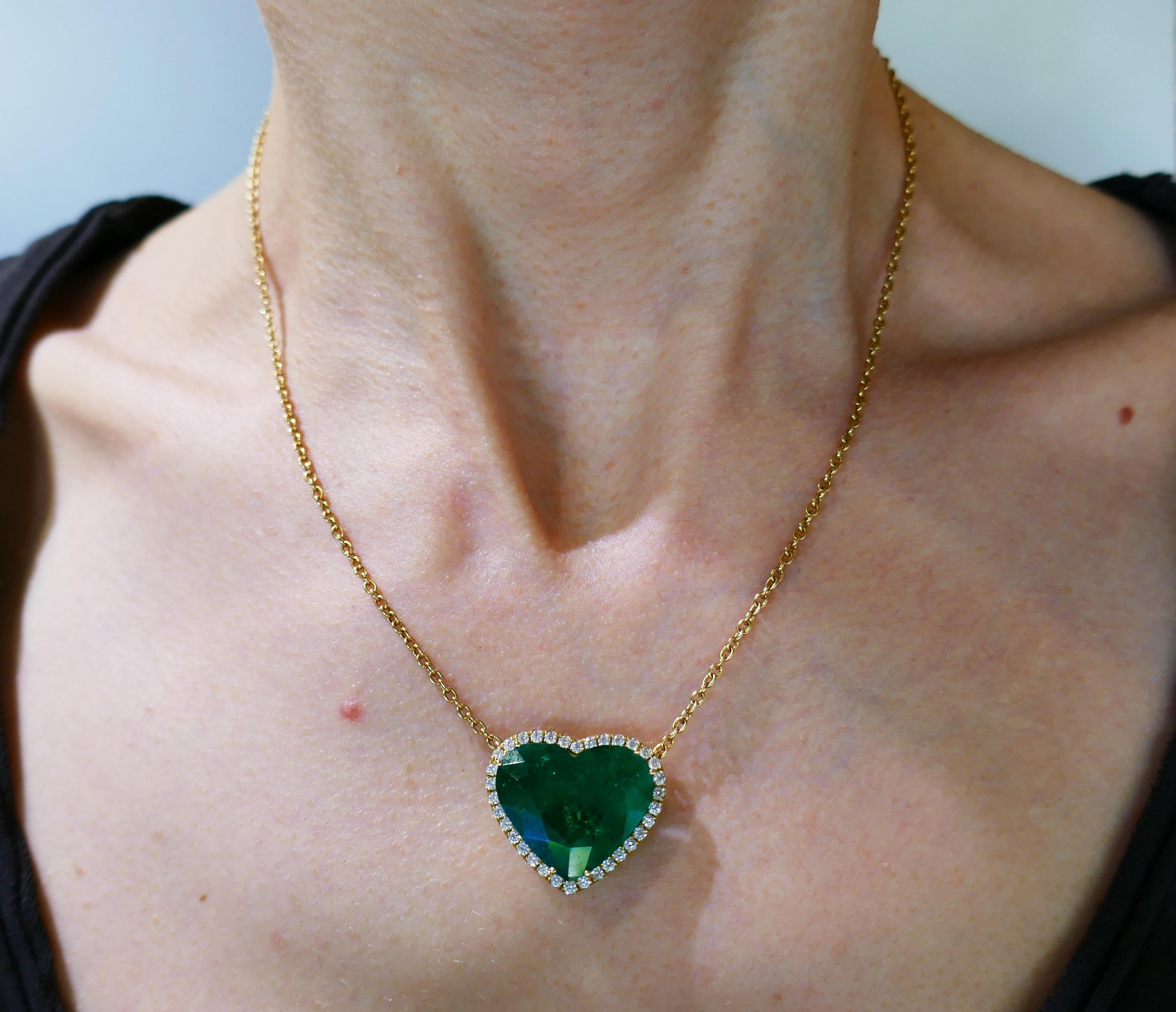 Romantic heart pendant necklace made of 18 karat yellow gold and featuring an approximately 11.40-carat heart-shape Zambian emerald in a diamond halo. The diamonds are round brilliant cut, G-H color, VS clarity, total weight approximately 0.34