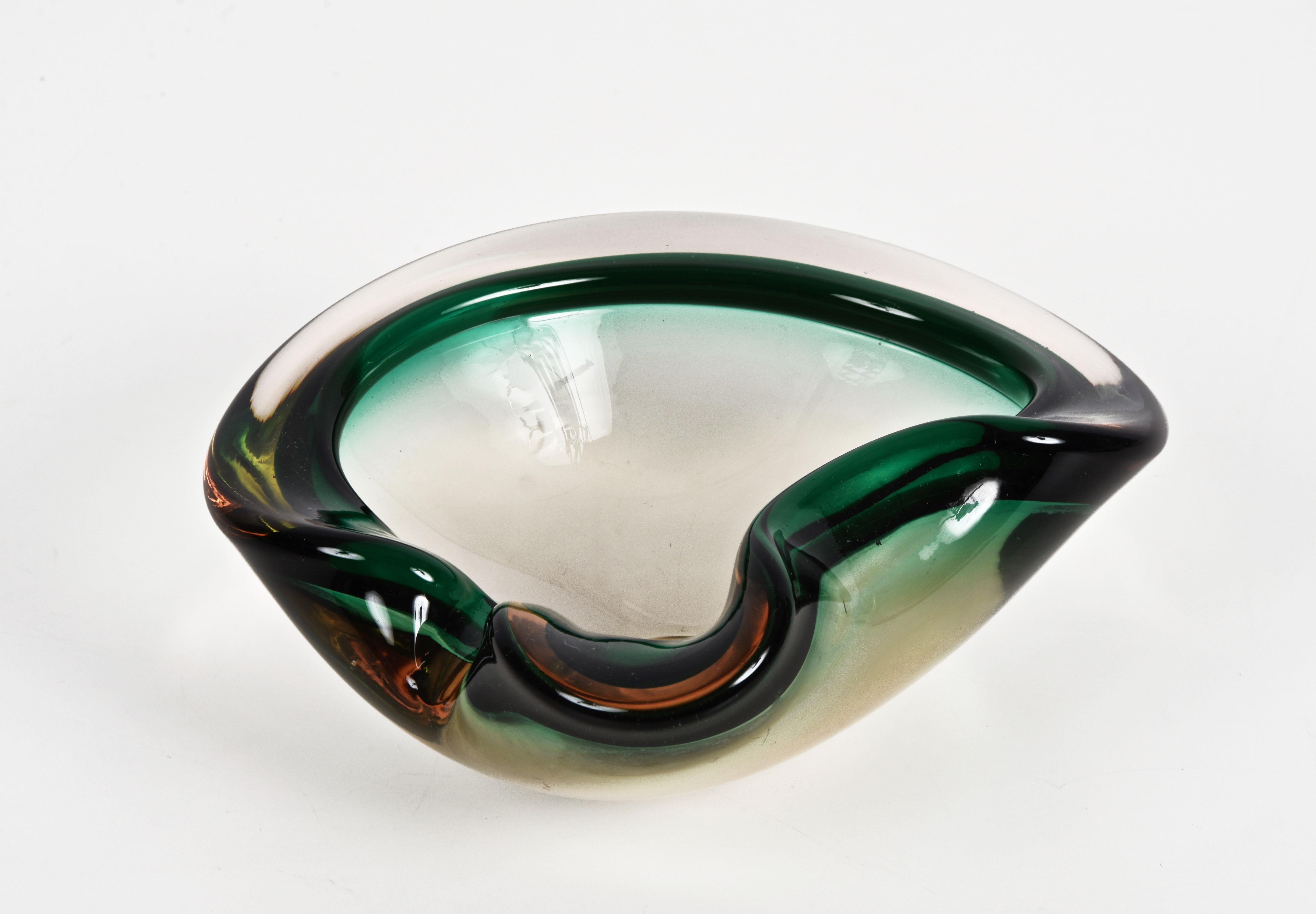 Magnificent heart-shaped, glass bowl or ashtray. Green, amber and crystal sommerso glass Murano, that was produced in Italy during the 1960s.

This wonderful piece is a perfect blend of sinuous lines and colors of the Murano glass due to the