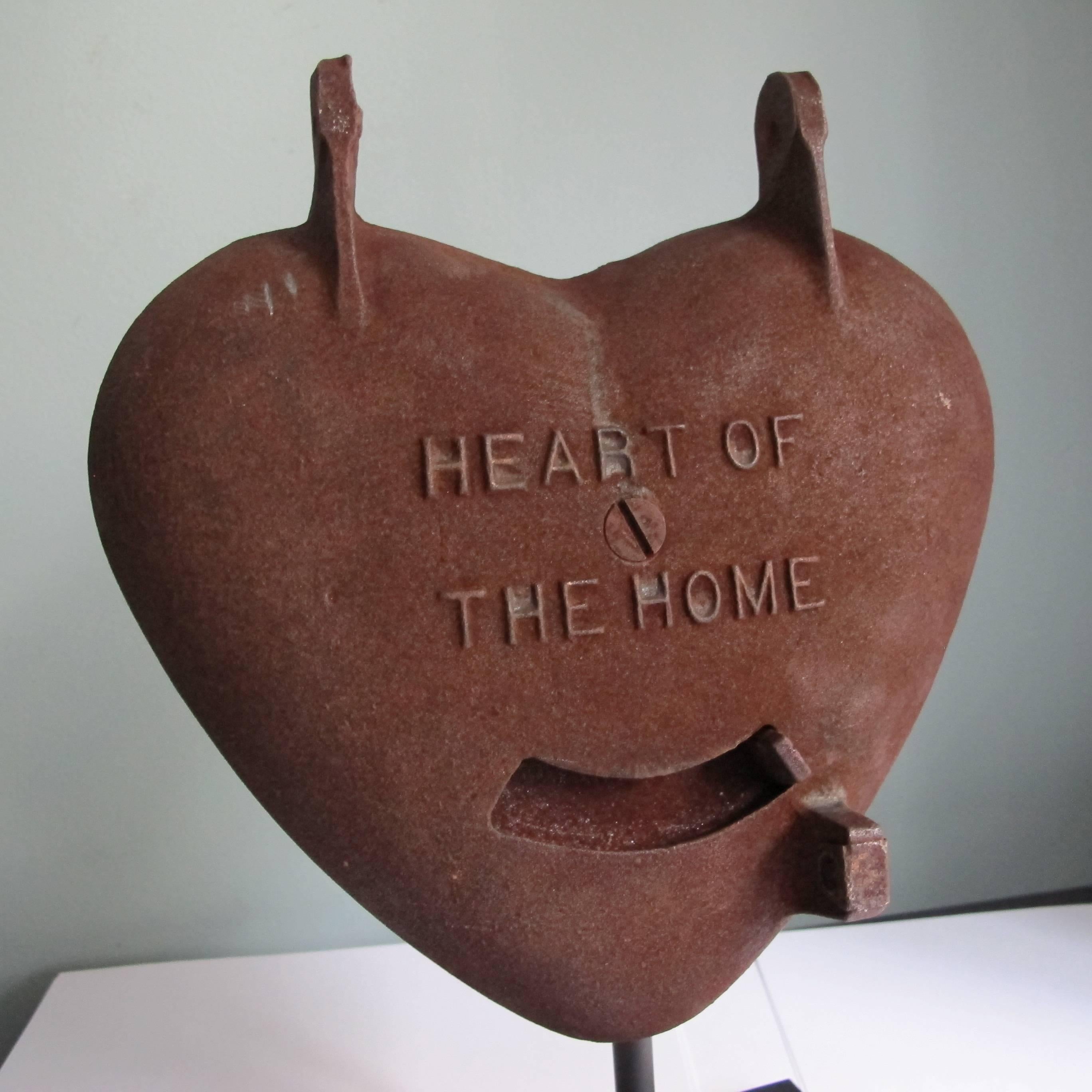The wood or coal stove used to be the heart of the home. One stove maker around used this sentiment in designing a stove door with a vent shaped like a heart. The heart shaped iron form with top hinges is now mounted over a black metal base as an