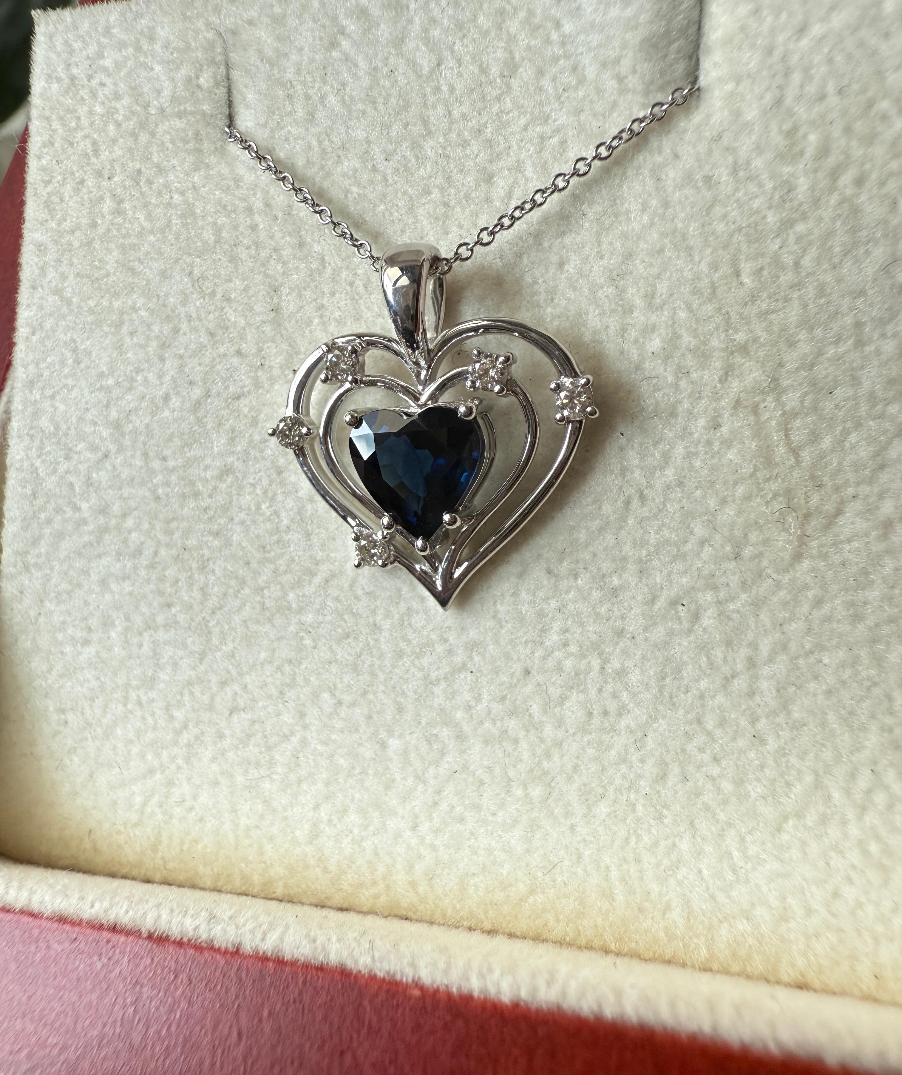 This exquisite 18K white gold pendant captures the essence of timeless romance in its elegant heart-shaped design. At its center lies a mesmerizing 1.24-carat heart-shaped blue sapphire, ethically sourced and heat-treated to enhance its rich, vivid