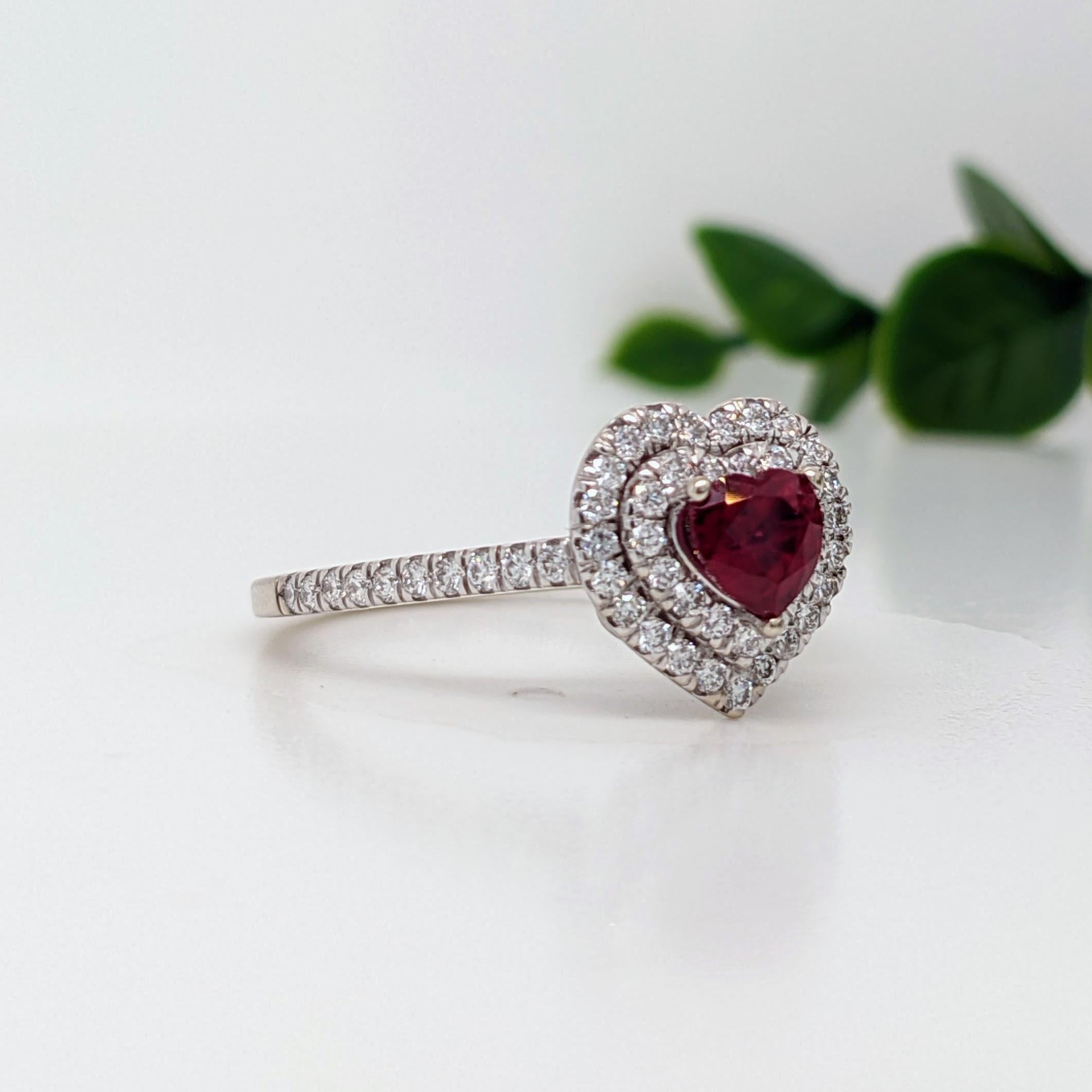 Celebrate love on all occasions with this vintage style diamond ring featuring a gorgeous pigeon-blood red ruby from Burma, framed by a heart-shaped double halo with natural earth-mined diamonds and a pave diamond studded shank. This design is