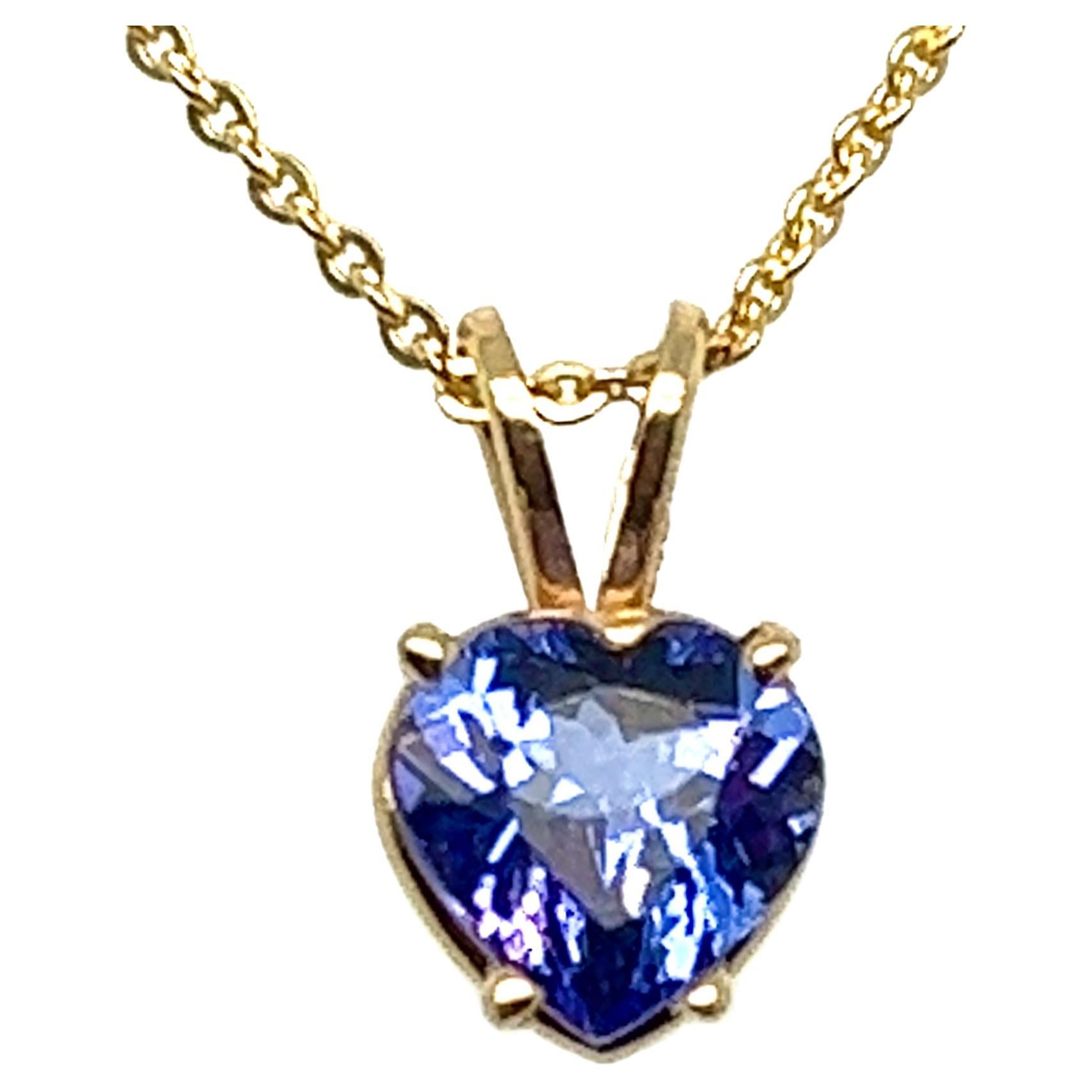 Offered here is a heart-shaped natural earth mined Tanzanite weighing 1.65 carats, 7.50mm by 7.40mm.
Vivid violet purple color, near flawless and mounted in a simple yet elegant 4 prong solitaire basket with rabbit ears bale, hanging on a solid 20