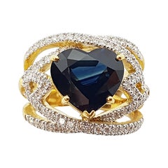 Anello con zaffiro blu a forma di cuore e diamanti incastonati in oro 18 carati
