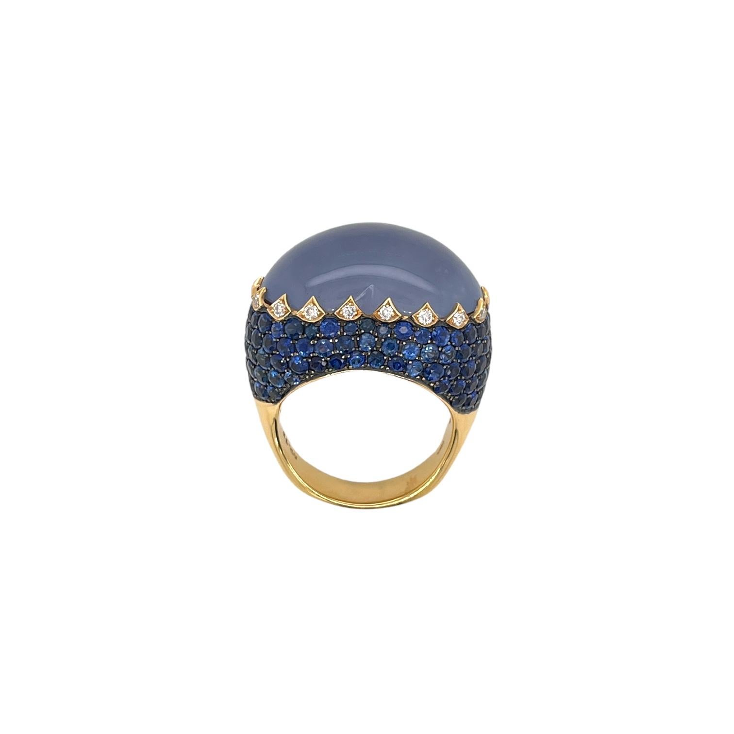 One of a kind large heart shape cabochon chalcedony gemstone, round sapphire and diamond ring in 18k yellow gold. Ring contains 1 center heart shape chalcedony 18.75ct. Center stone is accented by round sapphires, 5.53tcw and round brilliant