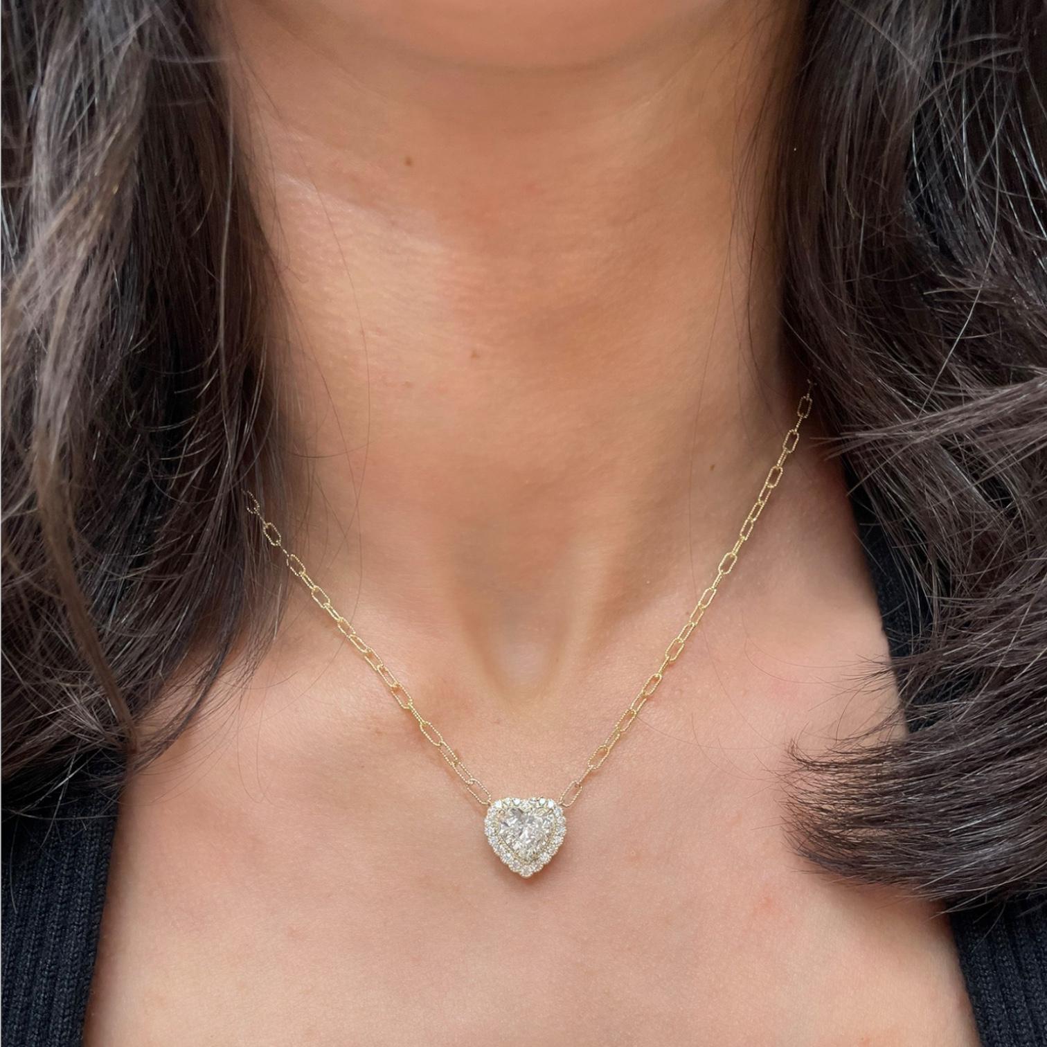 Pendant necklace contains one heart shape diamond, 2.02ct and round brilliant diamonds, 0.35tcw. Based on our opinion, center diamond is G in color and SI2 in clarity. Center diamond does not come with a lab report. Diamonds within halo are near
