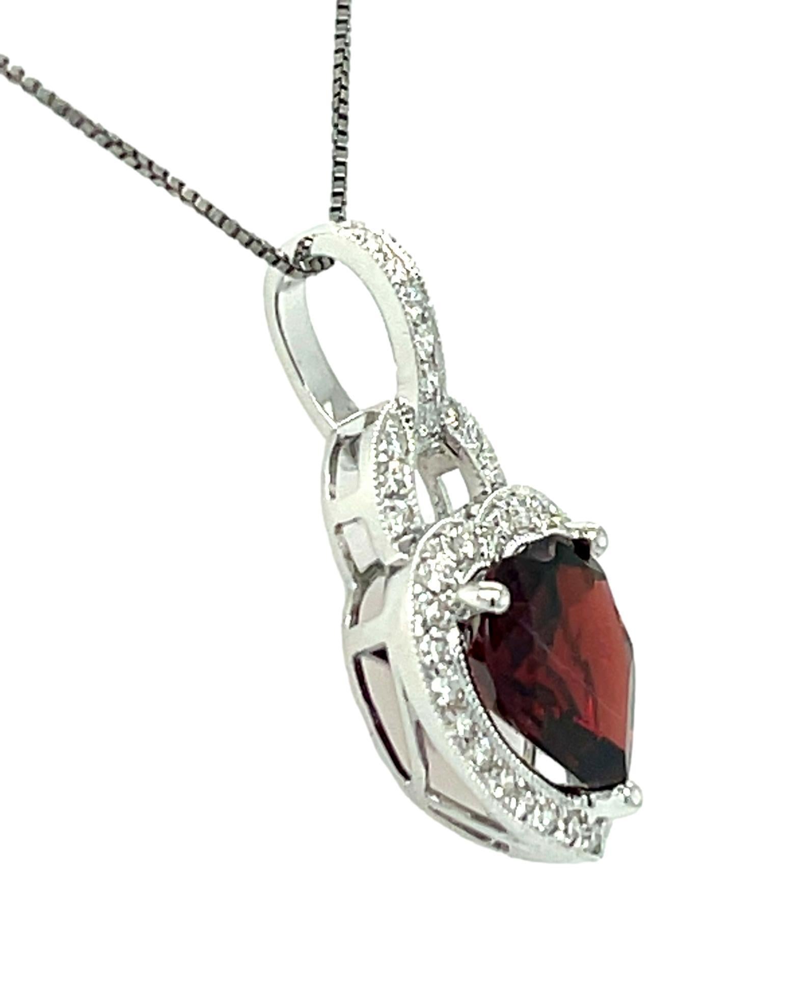 This stunning pendant has a deep red 9mm Heart-shape Garnet set in 14 karat white gold with 3 prong setting. There is a halo of brilliant cut round sparkling diamonds surrounding the Garnet for a delicate accent. This pendant will be shipped in a