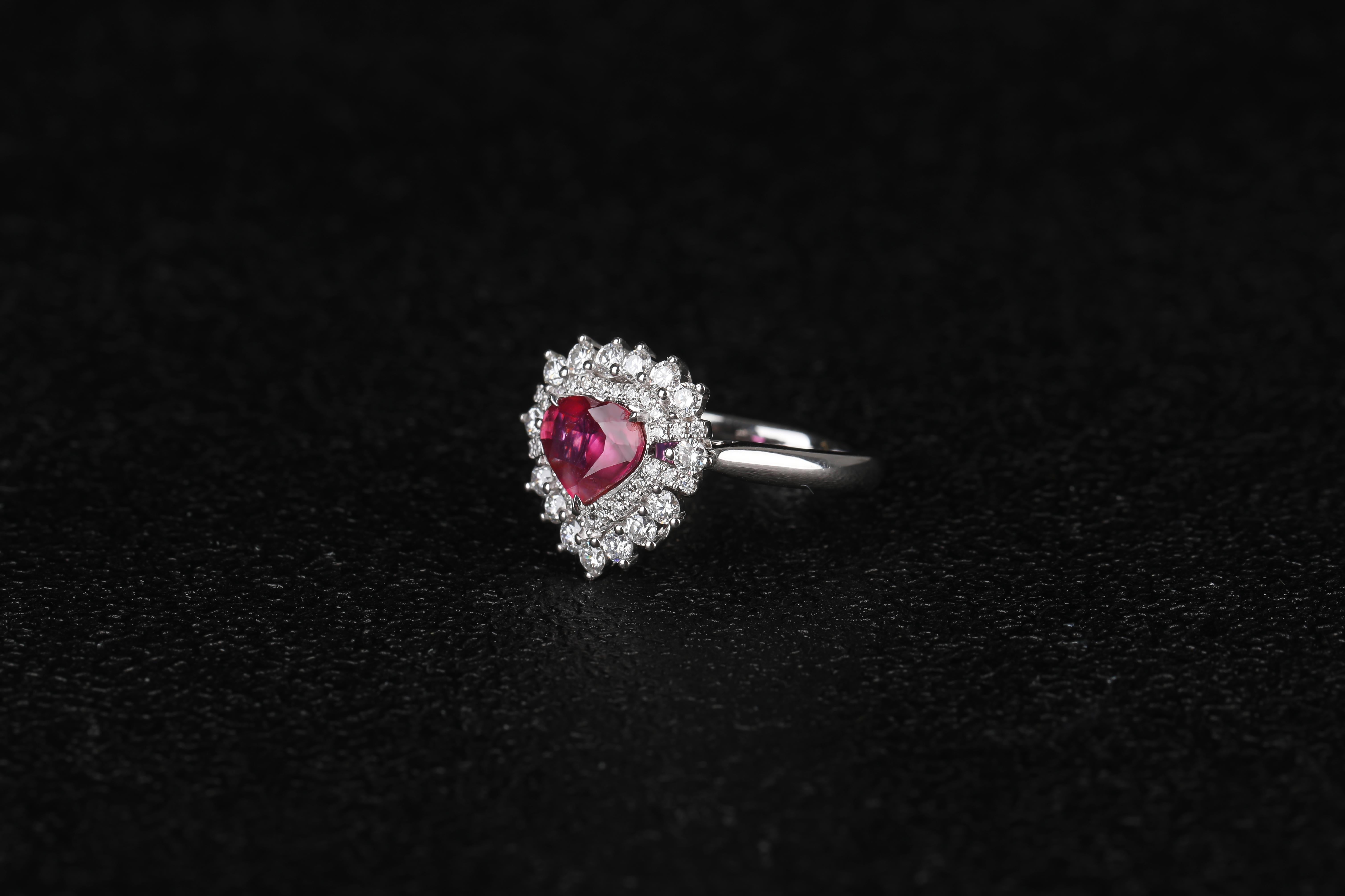 This is a heart shape ruby cluster ring.  The ruby is currounded by circles of diamonds, with the inner circle consists of smalle dianonds and the outer layer with significantly larger diamonds. It is a cute design as suited younger generation. It