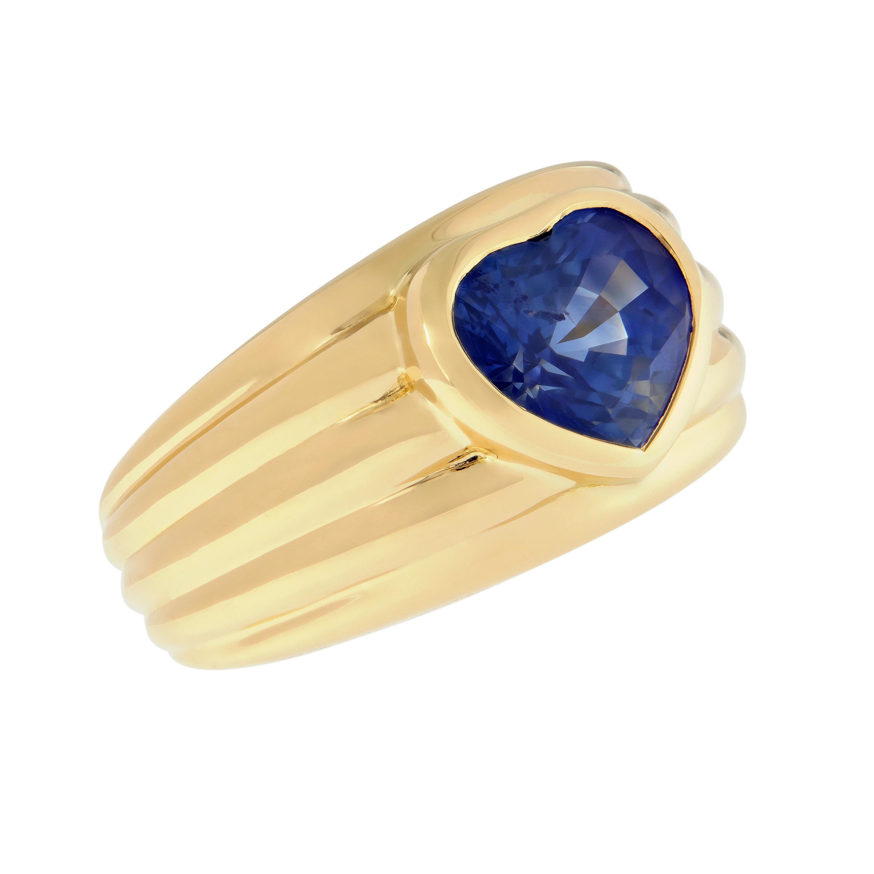 This ring features a bezel set heart-shaped blue sapphire center with ribbed grooves on the band adding to the charm of this 18k yellow gold band ring.  Perfect gift for Valentines Day, Mothers Day, Graduation, or just about any other occasion. Ring